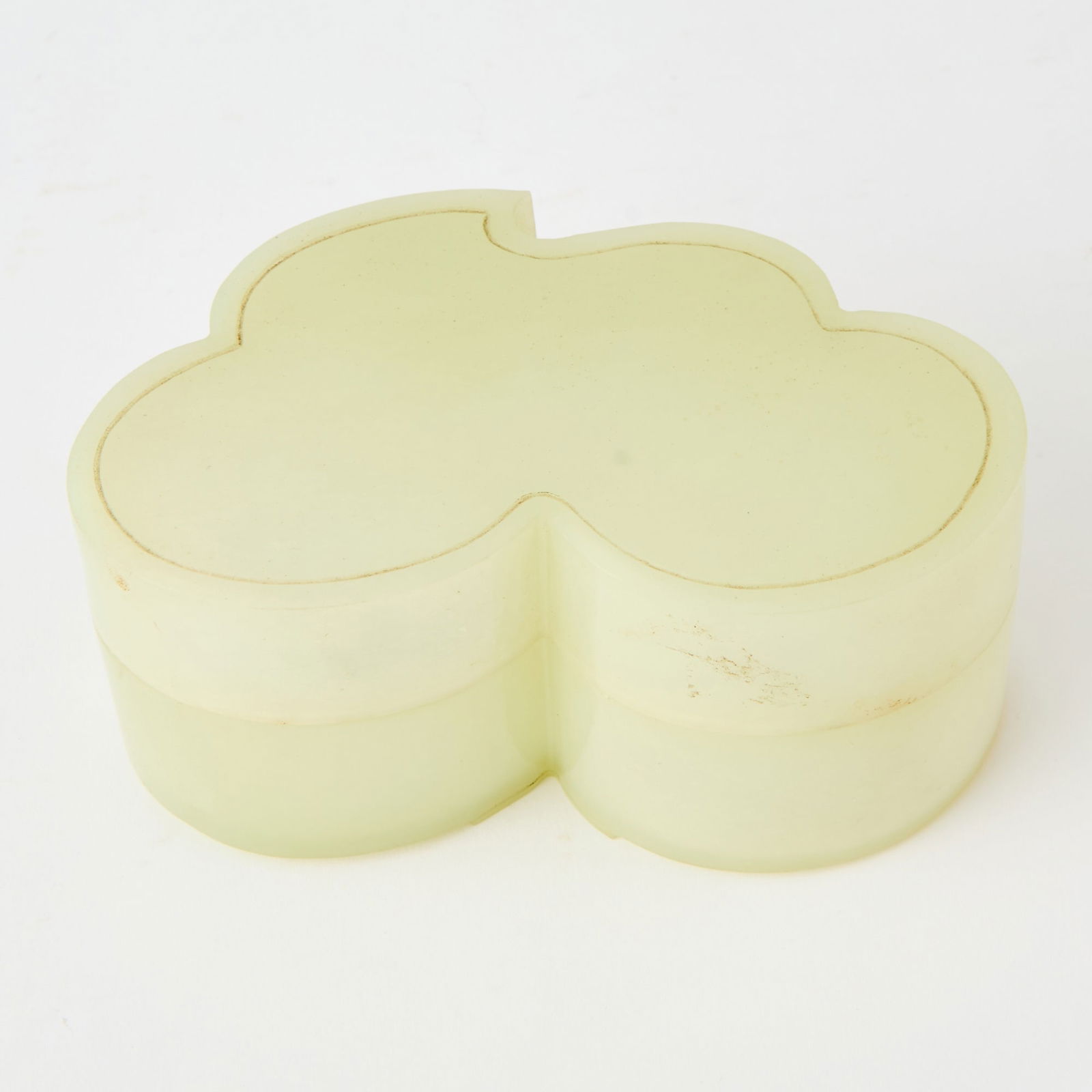 A Chinese Carved Jade Box and Cover Qing Dynasty: The leaf-form box raised on three short feet along the edge. (Length 5 inches)