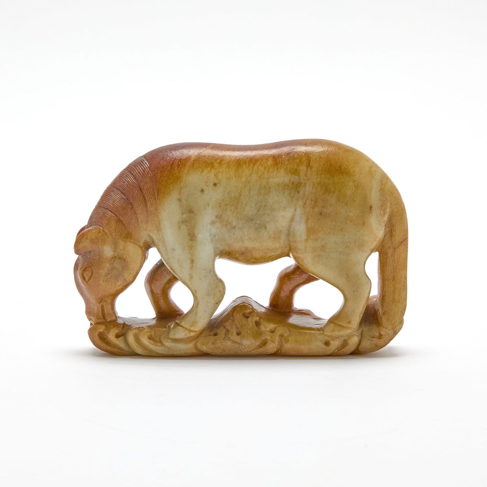 A Chinese Russet and Celadon Jade Figure of a Horse 18th Century: Carved as a standing horse with its head lowered and tail falling straight behind. (Length 6 inches)