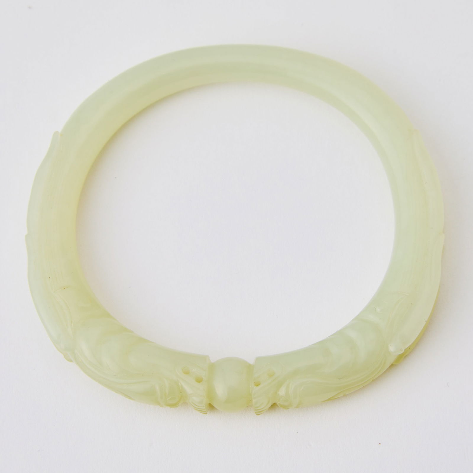 A Pair of Chinese White Jade Bangles 18th Century: Of circular form, carved with a pair of dragon heads chasing a pearl. (Diameter 3 inches)