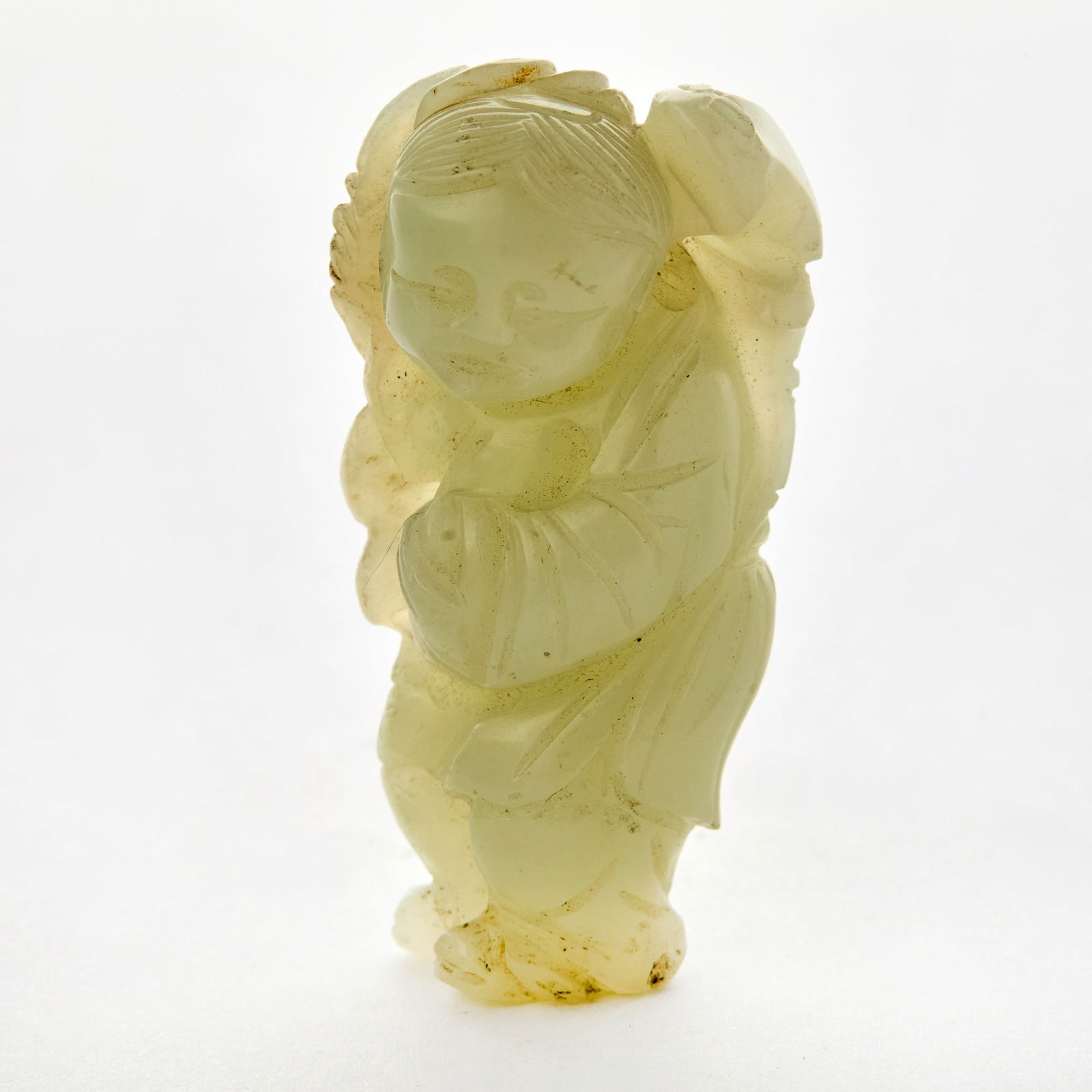 A Chinese White Jade Figural Carving Qing Dynasty: Depicting a youthful attendant with flower. (Height 2 inches)