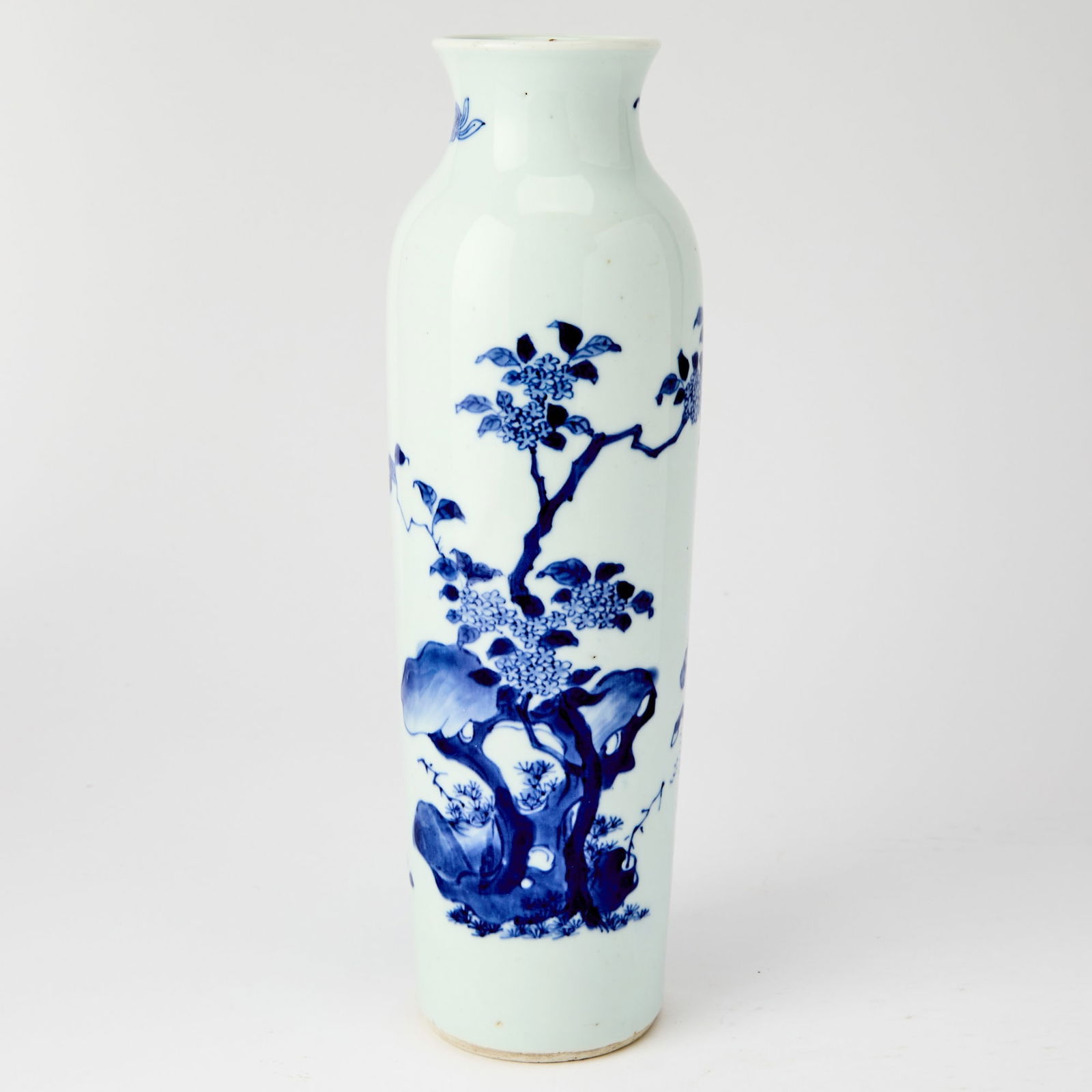 A Chinese Blue and White Porcelain Sleeve Vase 17th century: Decorated with an equestrian and a porter carrying loads on a shoulder pole amidst mountains, and flowers emerging from rockwork. (Height 10 3/4 inches)