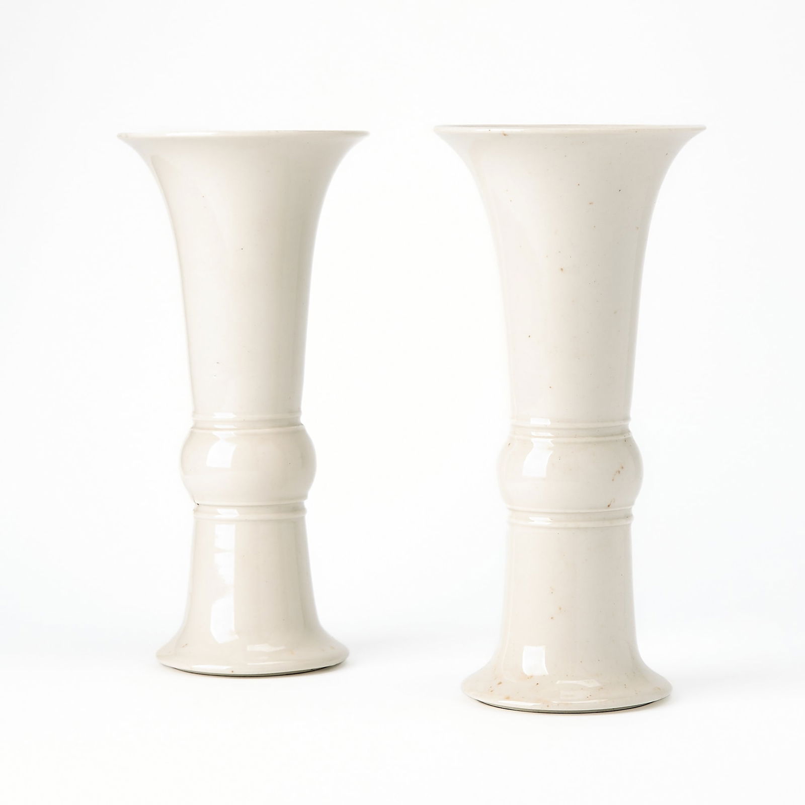 A Pair of Chinese White Glazed Porcelain Gu Vases Qing Dynasty: Of typical configuration, plain and unadorned. (Height 10 inches)