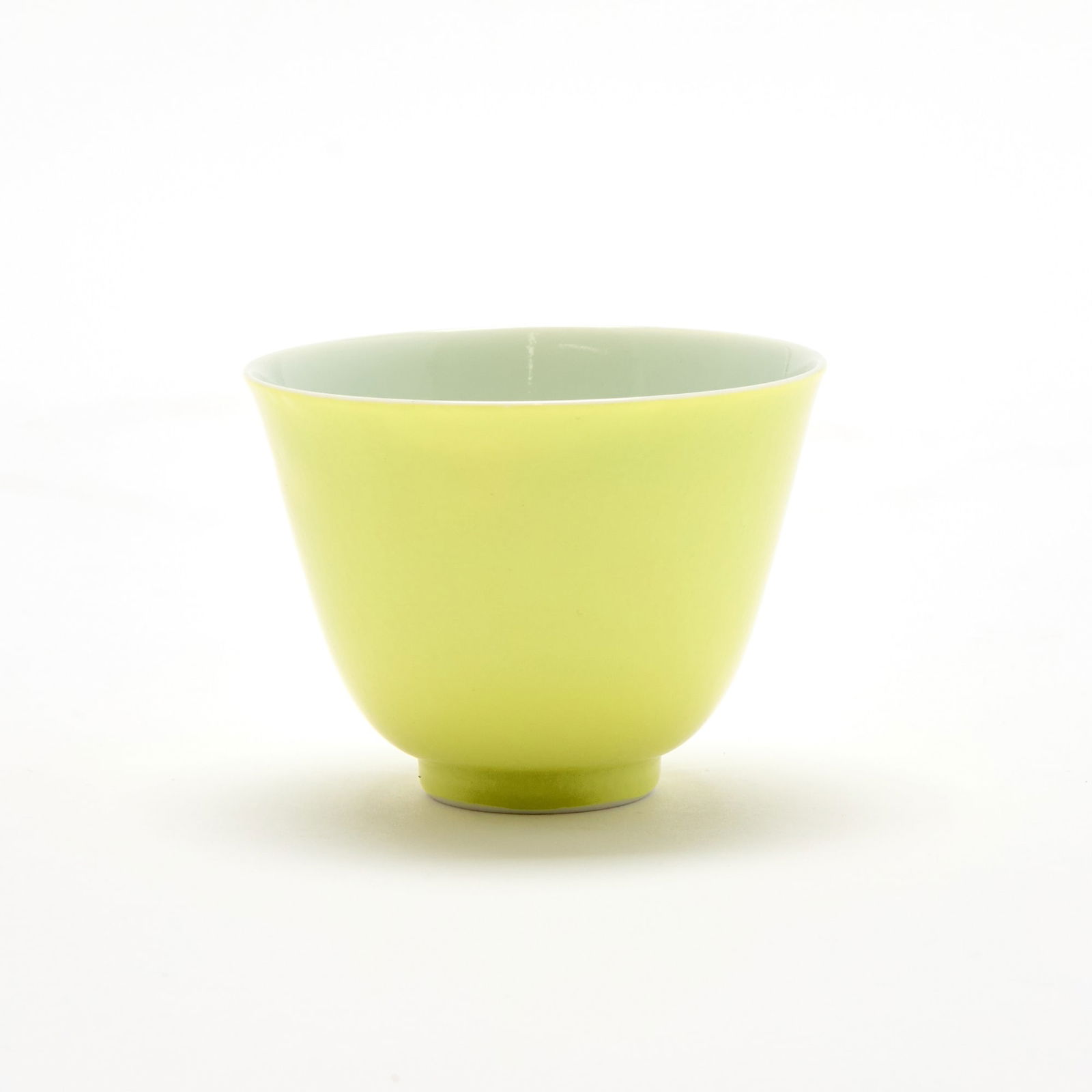 A Chinese Lemon Yellow Glazed Porcelain Cup Yongzheng Mark, 19th-20th Century: The gently flaring body raised on a short foot; covered to exterior in fine lemon yellow glaze. (Diameter: 2 7/8 inches)