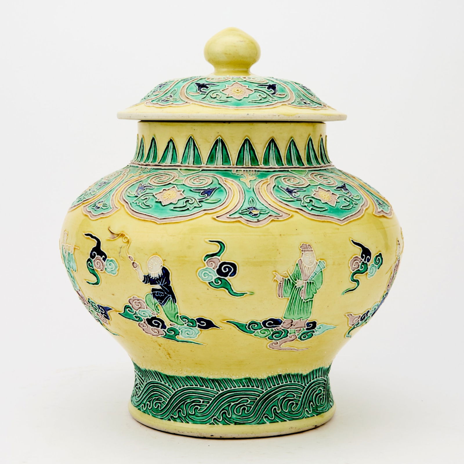A Chinese Fahua-Style Porcelain Jar 19th-20th century: Decorated in multicolor fahua glaze and with textured paste to show the Daoist immortals on clouds over a pale yellow ground. (Height: 12 inches)