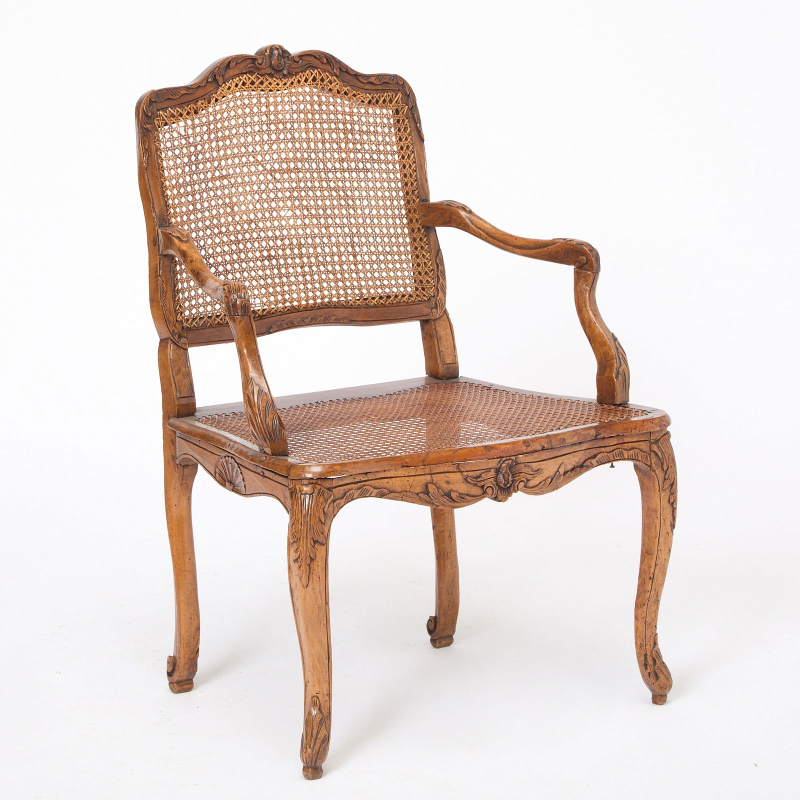Louis XV Caned Walnut Fauteuil: Mid-18th century Height 36 inches, width 25 inches, depth 19 inches.