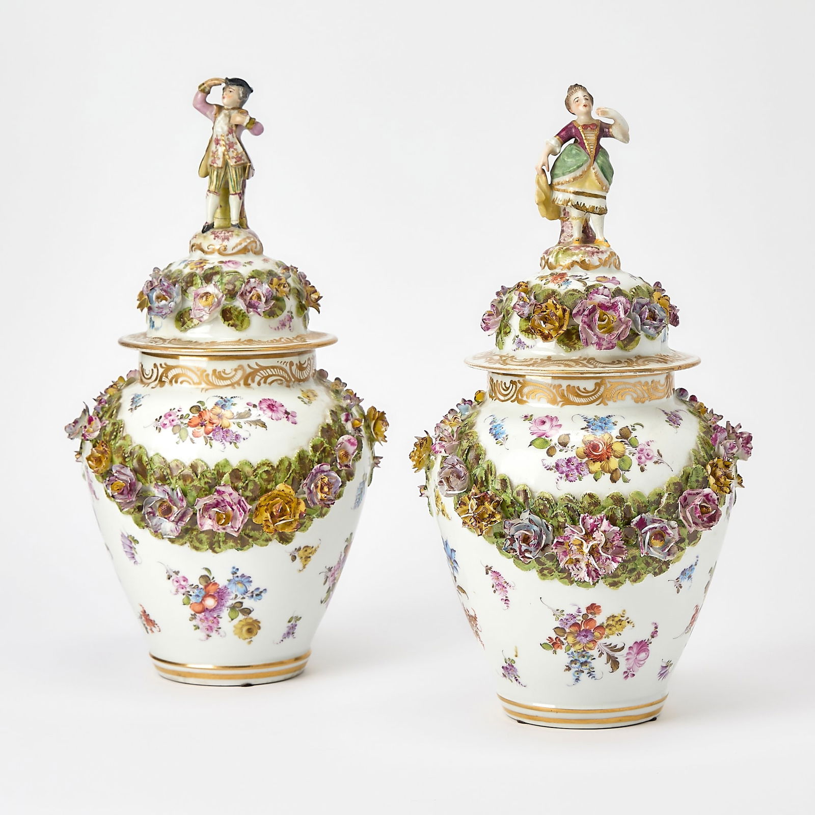 Pair of German Porcelain Urns and Covers: Height 15 inches. Losses and repairs