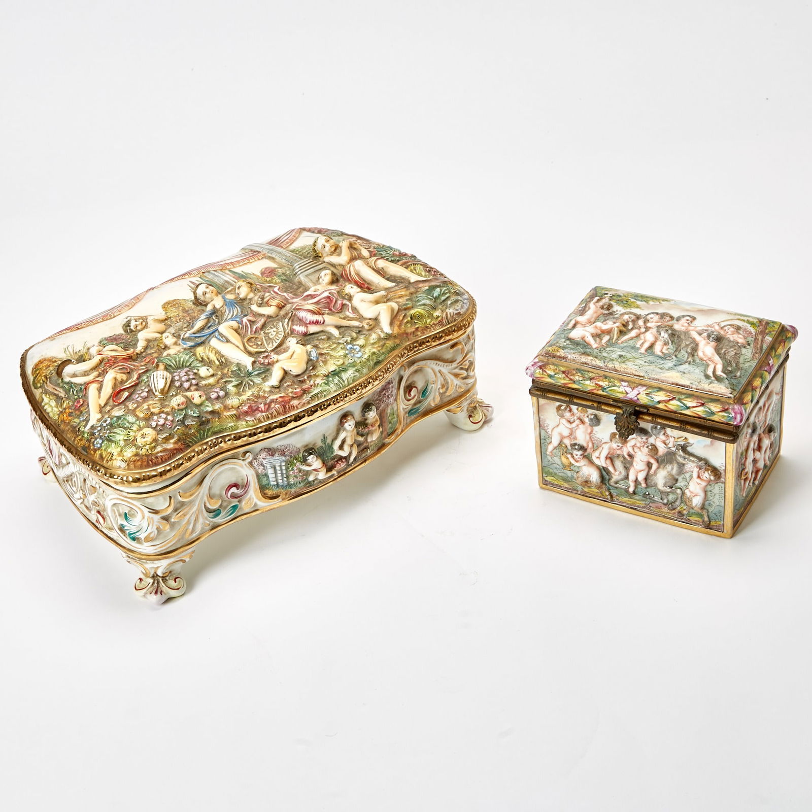 Two Capodimonte Style Porcelain Caskets: Height of larger 5 inches, length 12 inches, depth 8 inches. height of smaller 4 1/2 inches, width 6 inches, depth 4 1/2 inches