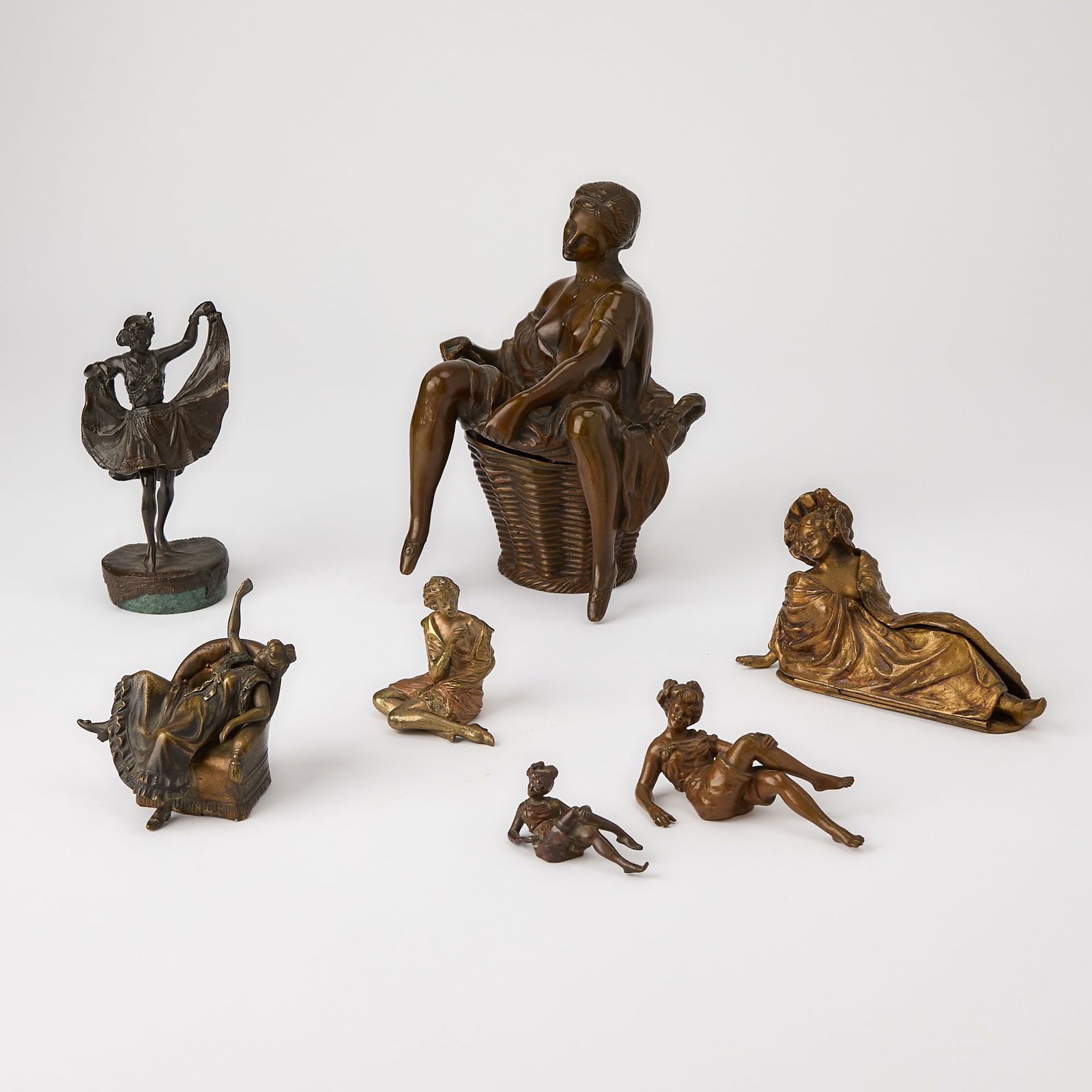 Group of Vienna and Vienna Style Patinated Bronze Erotic Figures of Women: Circa 1915-20 Comprising a two-part example in the form of scantilly clad young woman seated on a wicker basket, in reverie, unmarked, height 6 7/8 inches, width 5 inches; a young female dancer, entit
