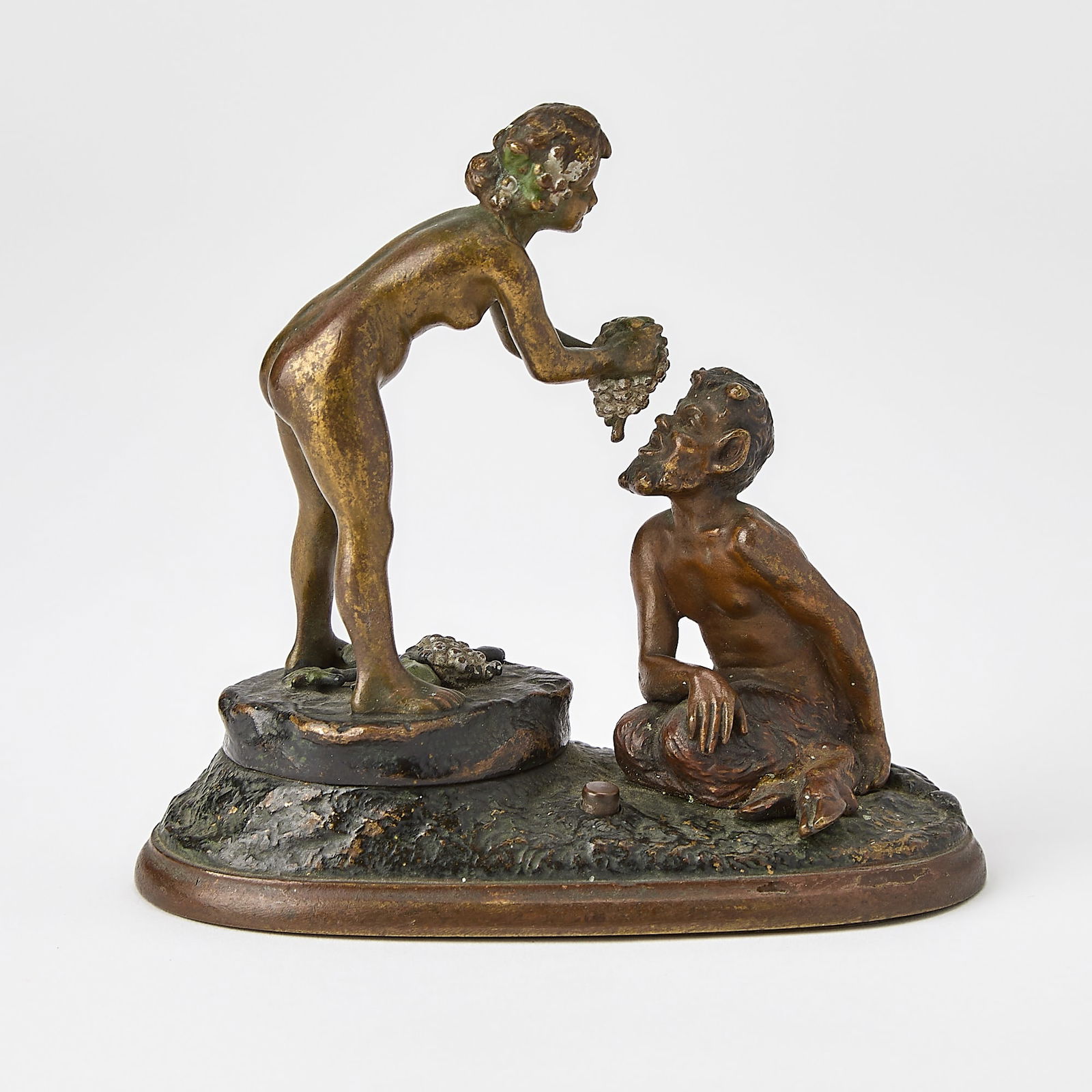 Vienna Cold-Painted Bronze Mechanical Erotic Group of a Nymph and Satyr: Attributed to Franz Xavier Bergman, circa 1915-20 Modeled as a nude young woman in a standing pose feeding grapes to a seated satyr, with a push button on the oval base that causes the nude figure to