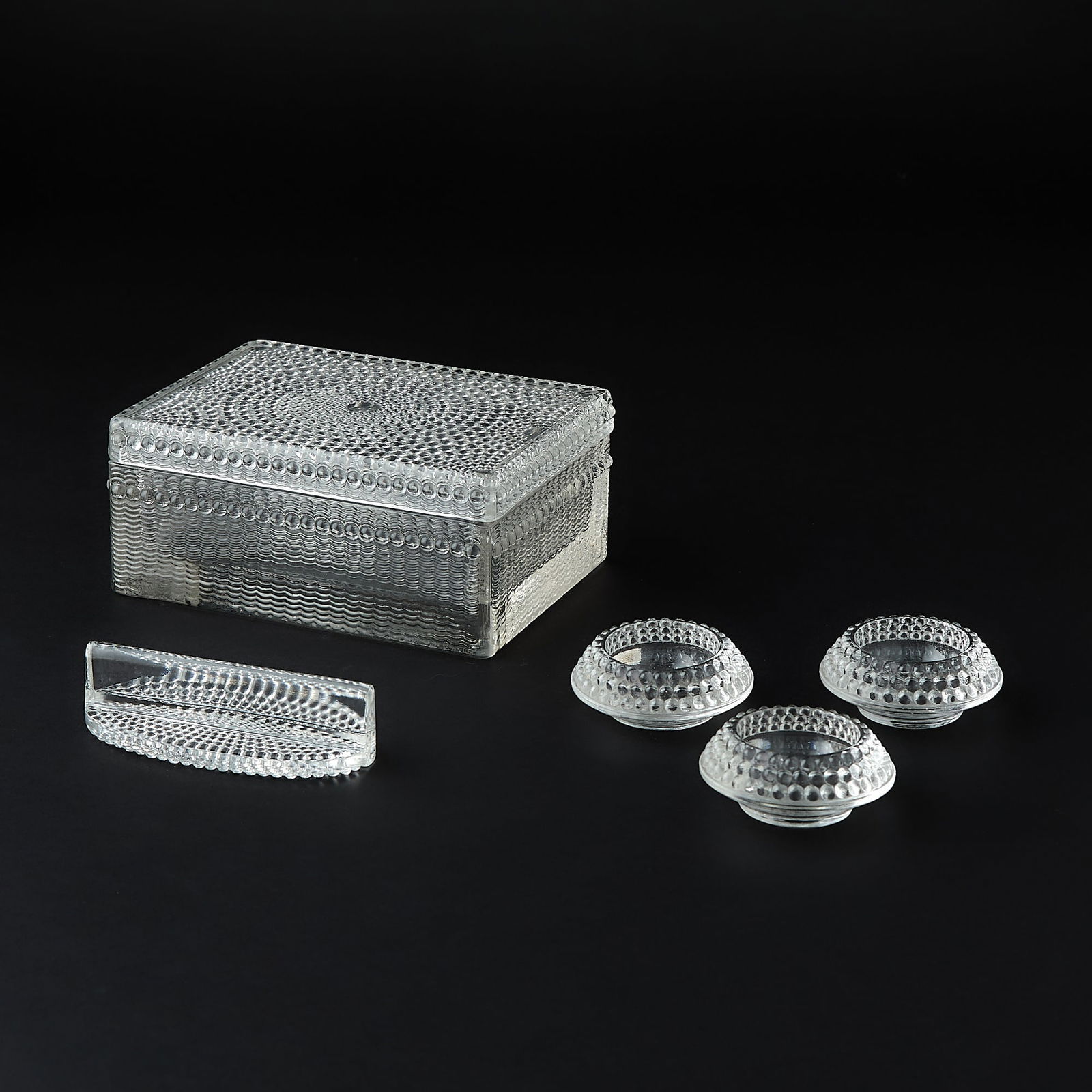 Five Lalique Molded Glass Articles: Comprising a Laurens box, a Nippon knife rest and three Nippon salts; all models introduce 1933; the box inscribed R Lalique France in script, all others acid-stamped R LALIQUE/FRANCE.Height of box 2