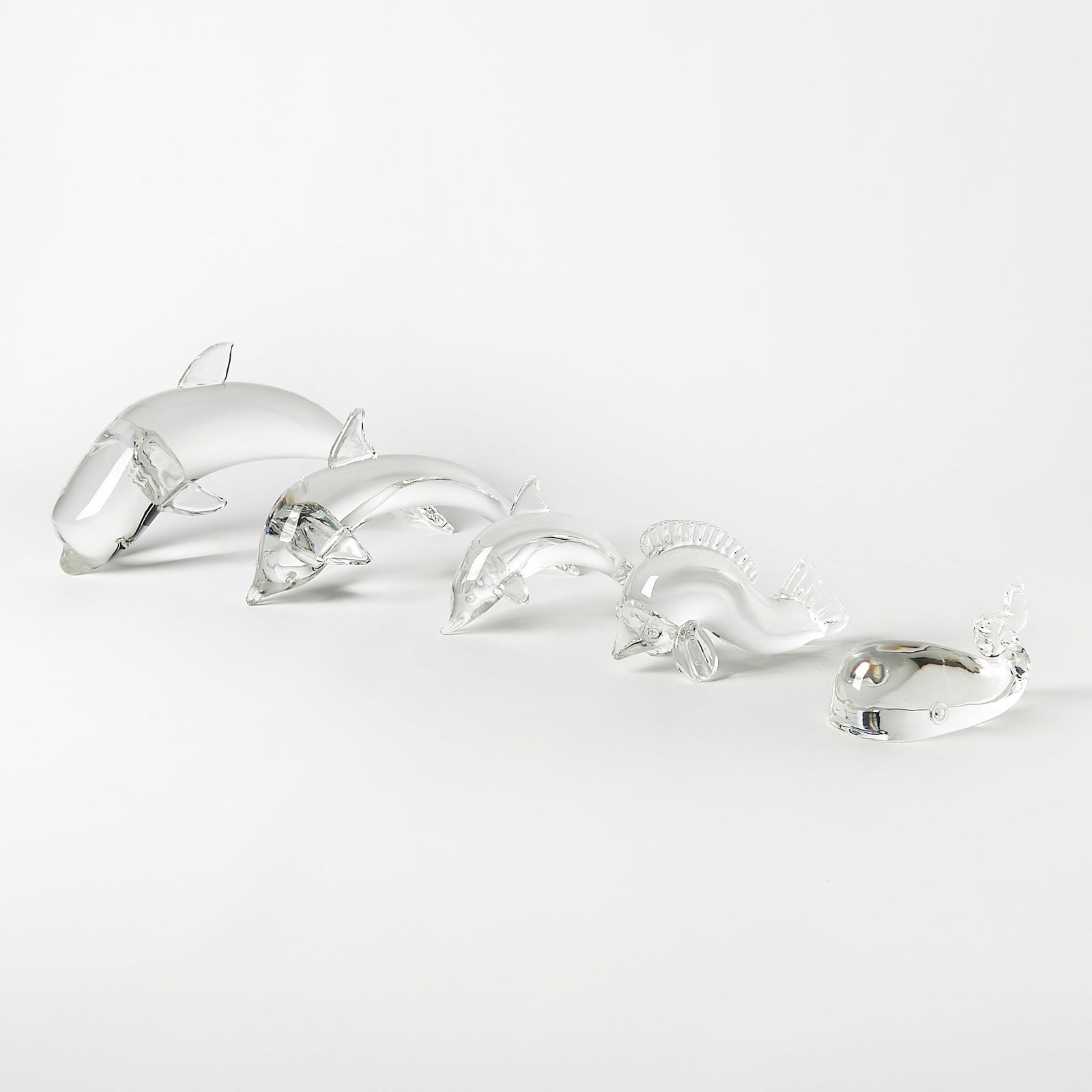 Four Steuben Glass Dolphins and a Whale: Lengths 5 to 12 inches. small dolphin missing a flipper and repair made to another flipper; all else in generally good condition