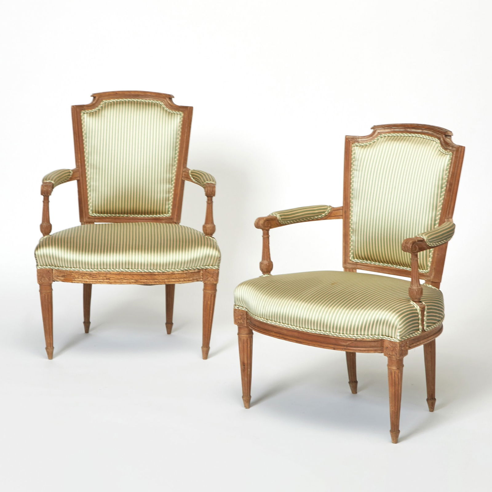 Pair of Louis XVI Upholstered Walnut Fauteuils: Height 34 inches, width 33 inches, depth of seat 18 inches, height of seat 16 inches. dry wood; some water staining; evidence of old woodworm; some cracking