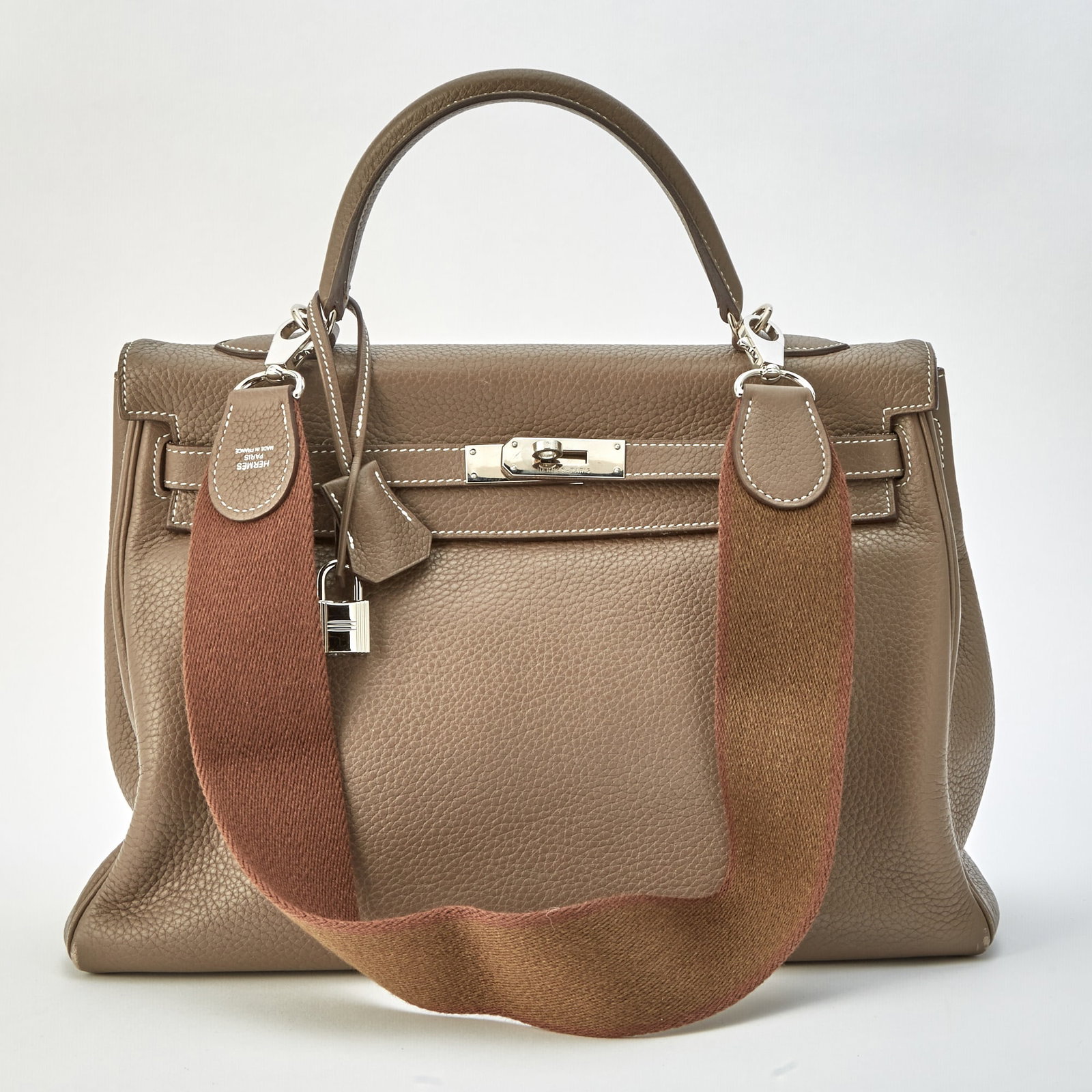 Hermès Etoupe Togo Leather Retourne Kelly 35 Bag: Top handle bag with palladium hardware and turn-lock closure, lock, keys and clochette, matching leather interior with one side zippered pocket and two slip pockets, with detachable fabric strap, sign
