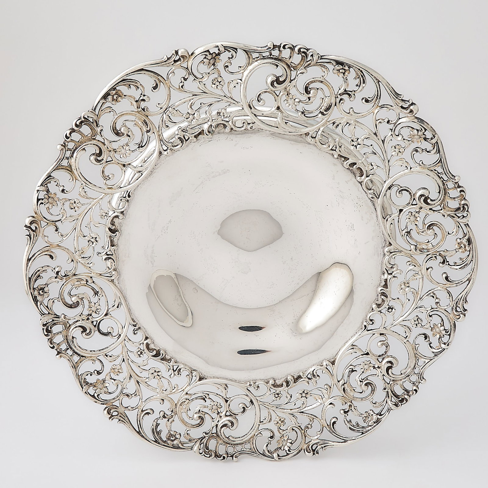 Howard & Co. Sterling Silver Footed Dish: Late 19th/early 20th century Shaped circular with openwork foliate scroll border, on a ring foot. Height 1 3/4 inches, diameter 13 1/2 inches, approximately 40 ounces. Generally good condition overa