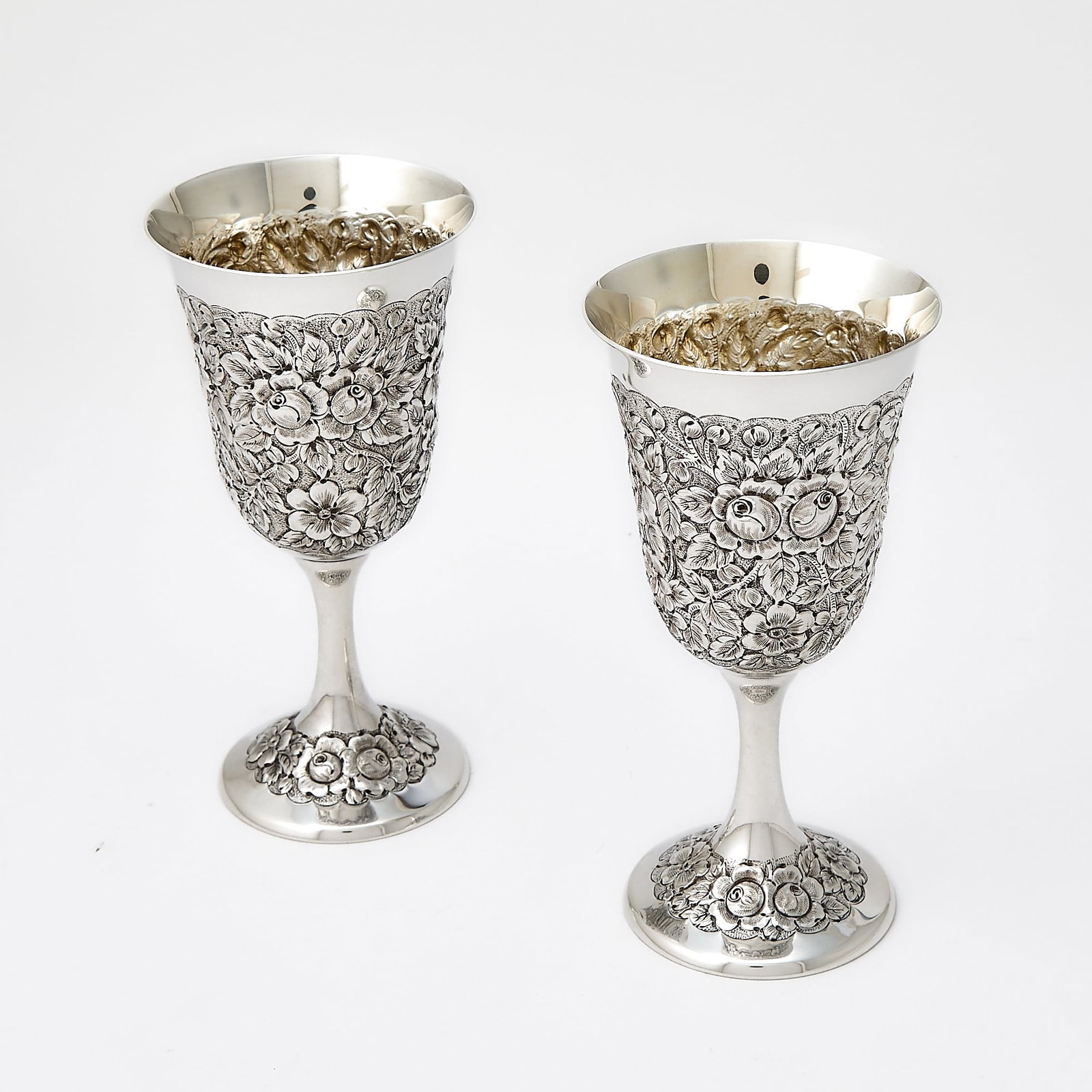 Pair of American Sterling Silver Goblets: 20th Century Each inverted bell-form, chased overall with floral repousse. Height 6 3/4 inches, total approximately 9 ounces. Generally good condition overall