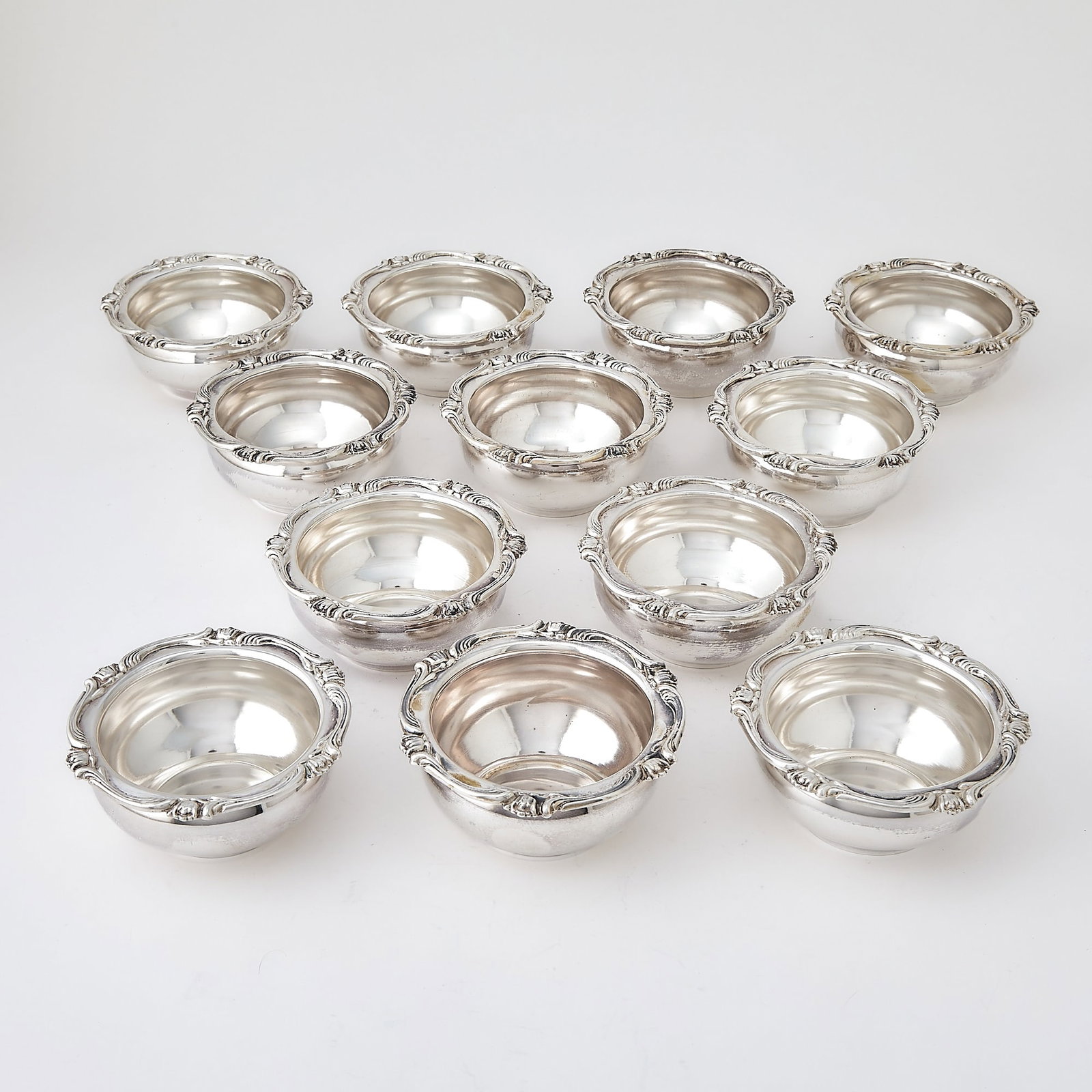 Set of Twelve Peruvian Silver Bowls: Welsch, mid 20th century Each ciruclar with applied scroll border. Height 2 1/8 inches, diameter 4 3/4 inches, total approximately 51 ounces. Generally good condition overall Marked 900 standard