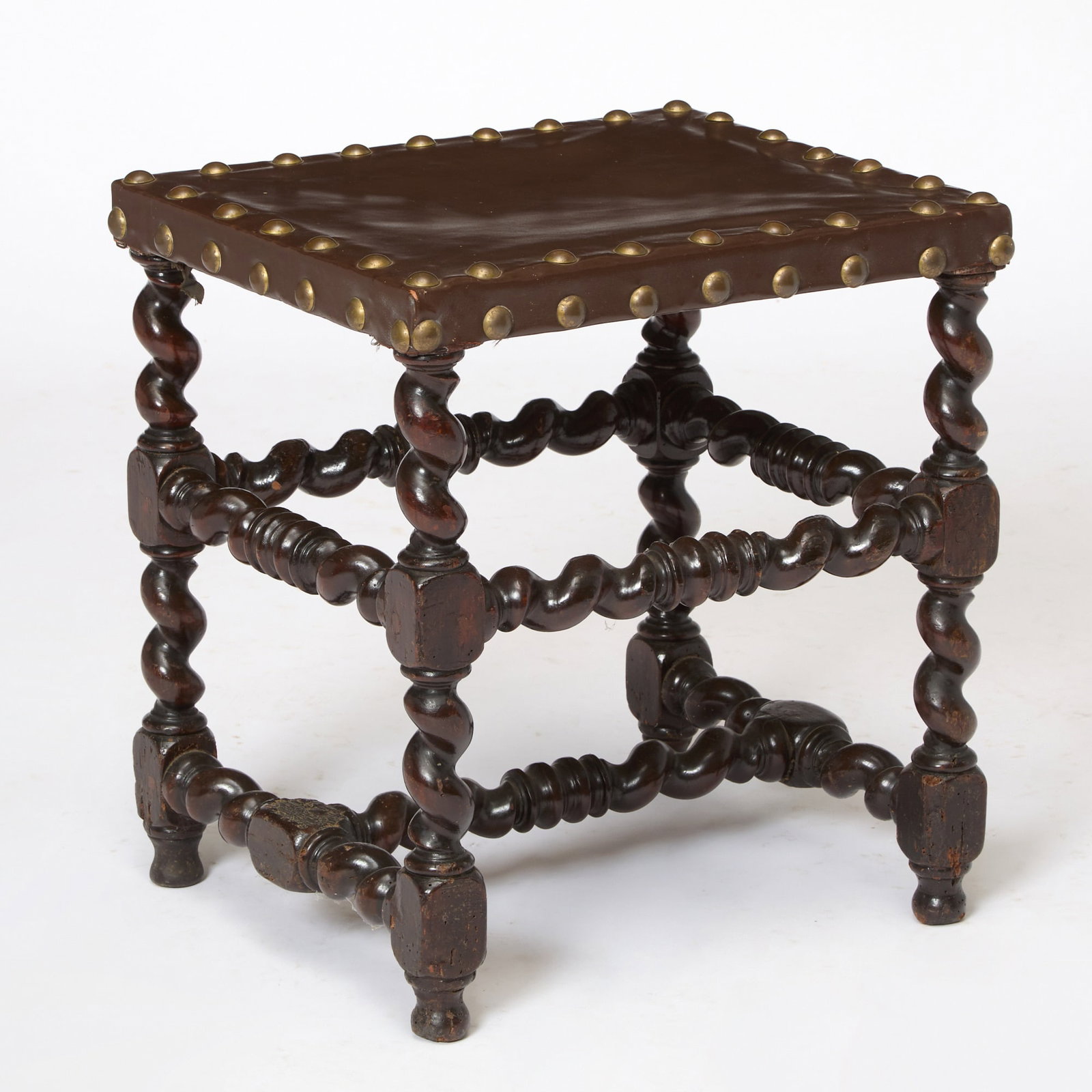 William and Mary Walnut Stool: 17th CenturyThe brass studded leather seat above barley twist legs. Height 19 1/4 inches, width 17 3/4 inches, depth 15 3/4 inches.