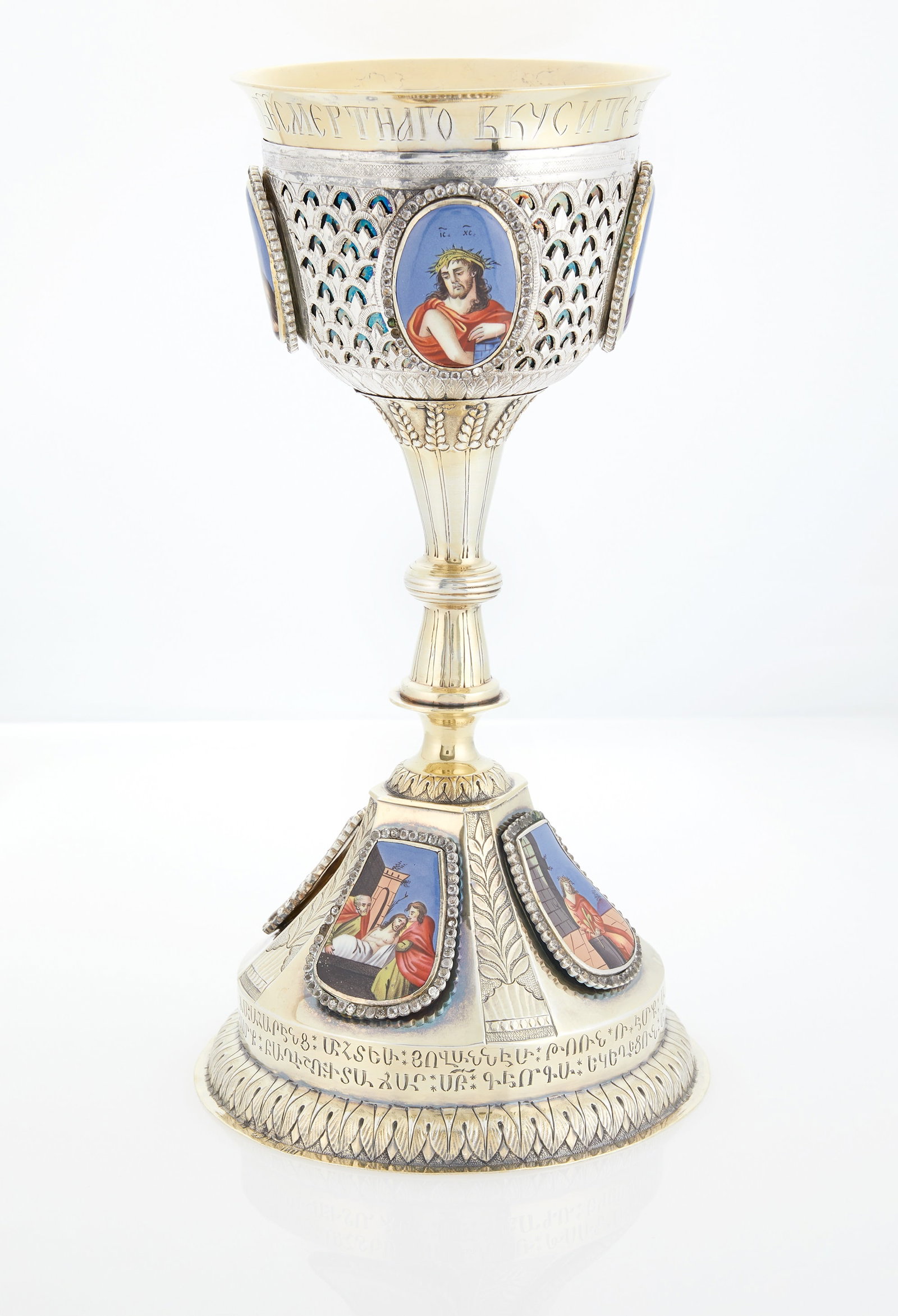 Russian Paste-Set, Enamel-Mounted Parcel-Gilt Silver Chalice: Maker's mark ВП, Moscow, 1819 Goblet form, the domed spreading foot with a stiff leaf border, set with finift enamel plaques depicting the Passion of Christ, bordered by paste stones, abov