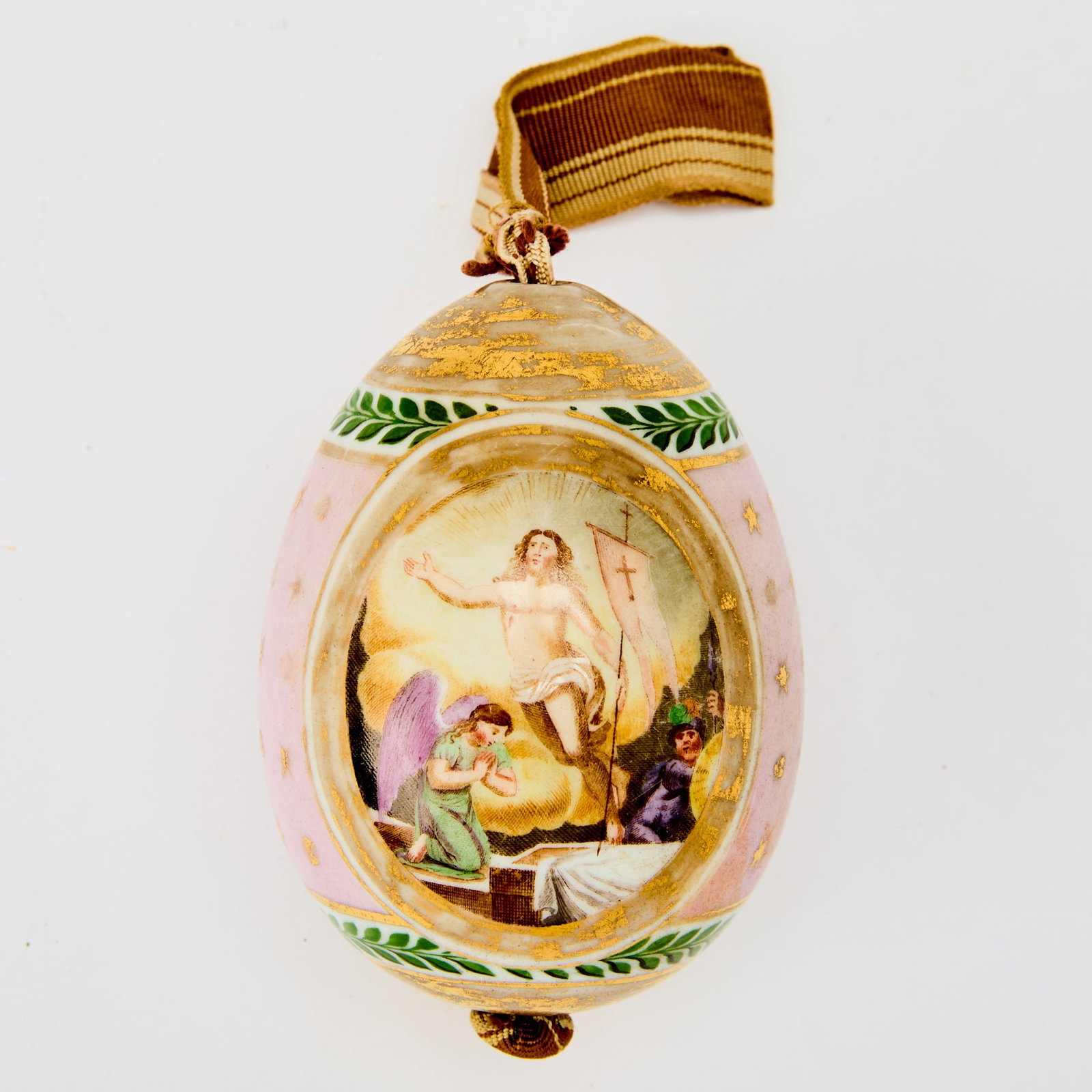 Russian Porcelain Easter Egg: Probably Imperial Porcelain Manufactory, St. Petersburg, 1820s Ovoid, decorated with gilt stars on a pink ground, with green foliate borders, the front reserved with the Resurrection of Christ, the re