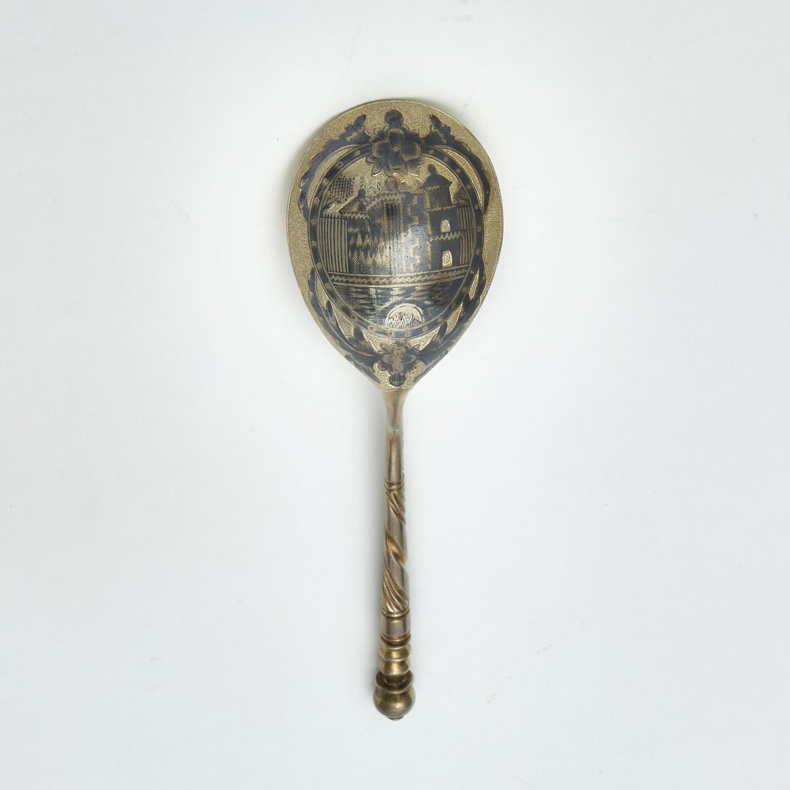 Russian Silver-Gilt and Niello Spoon: Maker's mark ФП, Moscow, 1820s The pear-shaped bowl nielloed with an architectural view, with a spiral-twist stem. Length 7 inches (17.8 cm).