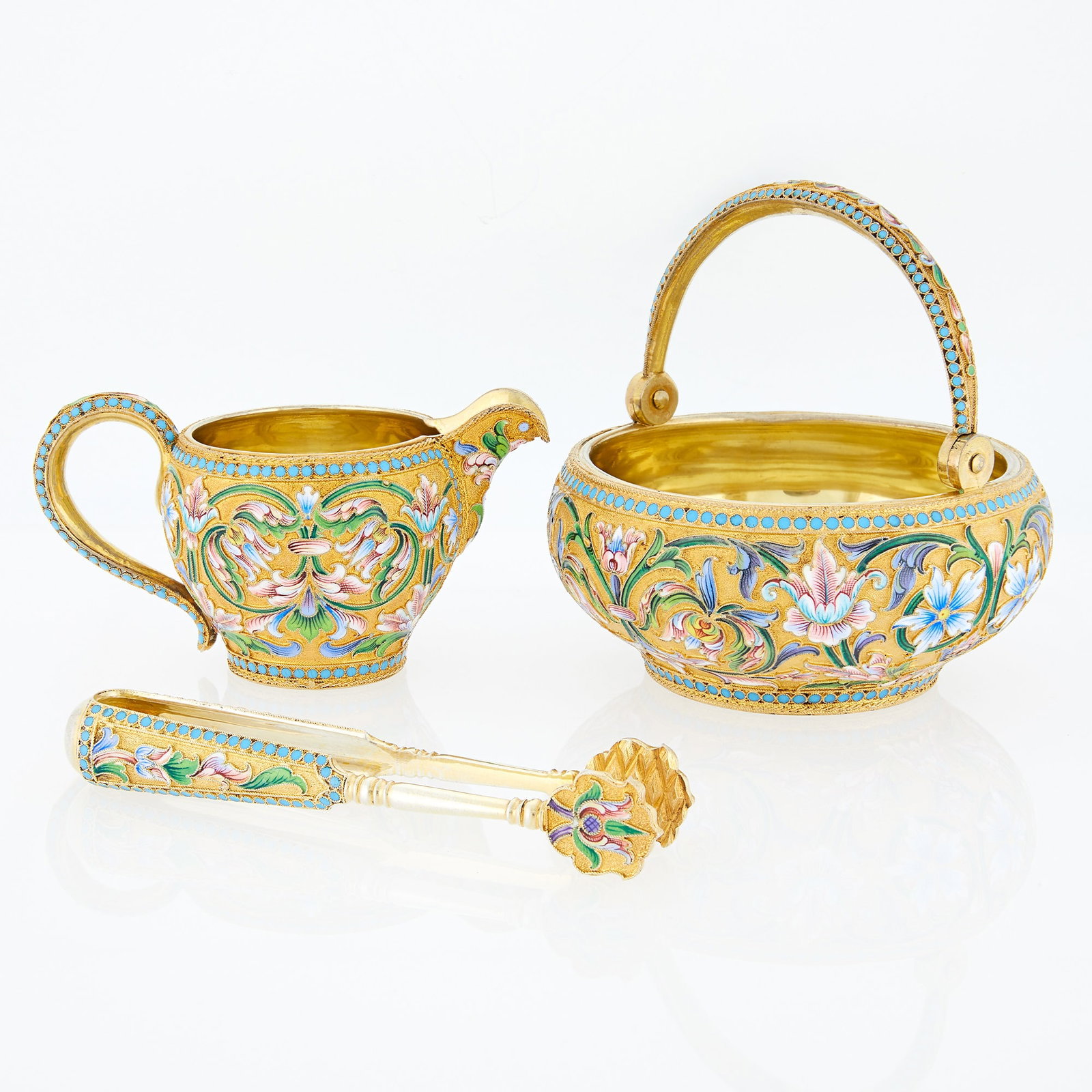 Russian Silver-Gilt and Cloisonné Enamel Sugar Bowl, Cream Jug and Sugar Tongs: Maria Semenova, Moscow, 1899-1908 Each of typical form, enameled with varicolored shaded flowers and foliage within turquoise pellet borders. Diameter of sugar bowl 3 7/8 inches (9.8 cm), length of cr