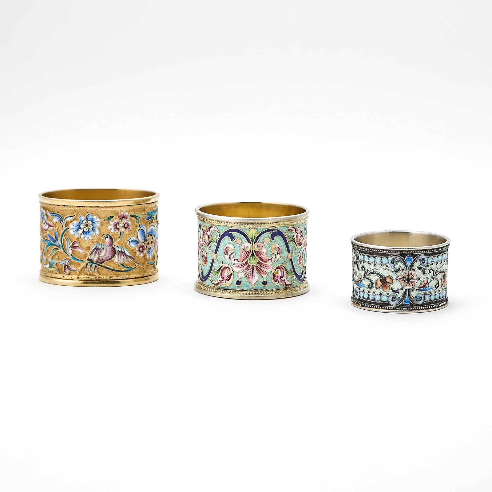 Group of Three Russian Silver and Cloisonné Enamel Napkin Rings: Various makers, Moscow, 1899-1917 Each of typical form, enameled with varicolored shaded flowers and foliage. Width of largest 2 1/8 inches (5.4 cm). Makers (left to right in photo): N. Zverev, 1908-