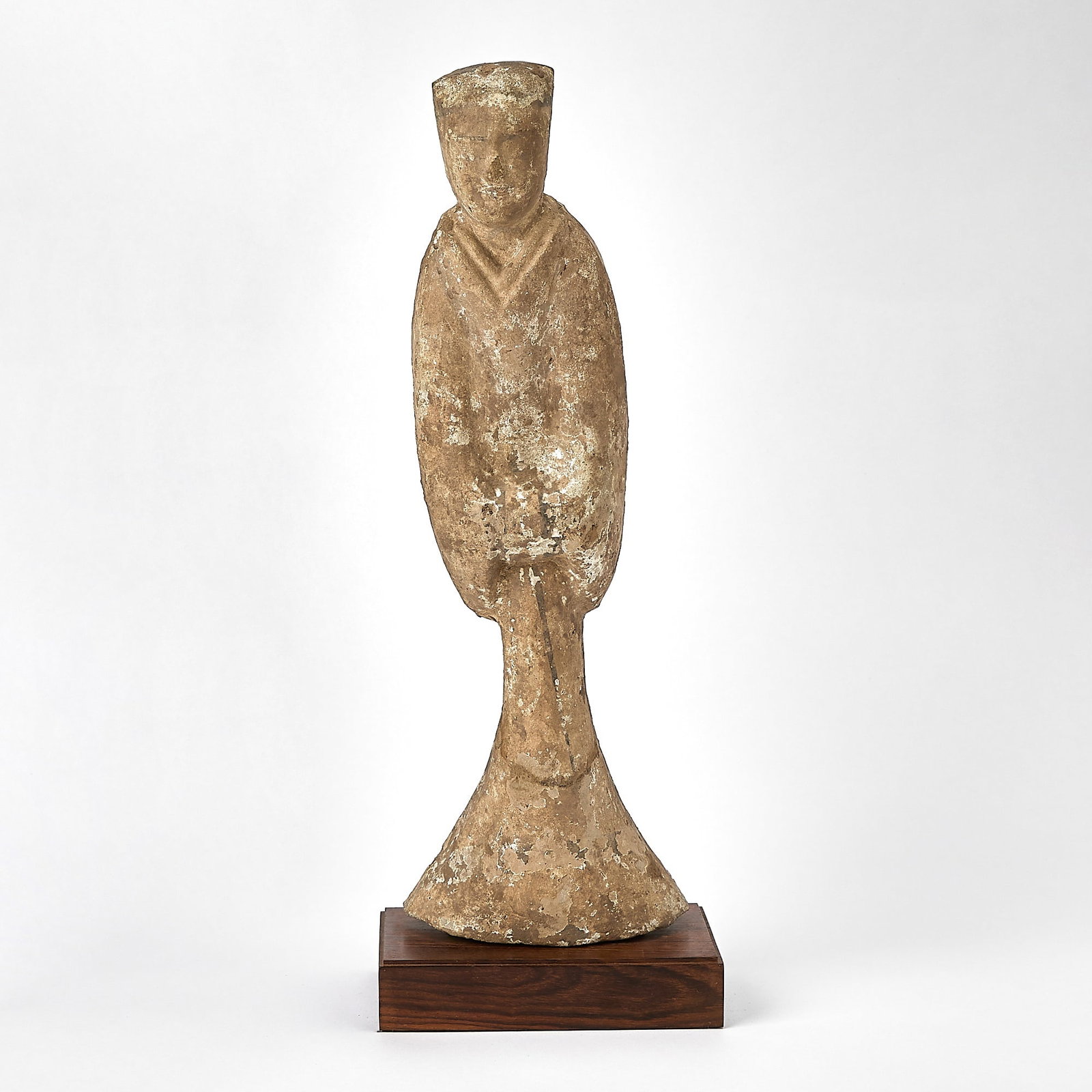 Chinese Pottery Figure of an Attendant Han Dynasty: The standing figure dressed in a long robe flaring at the base, her hands clasped beneath voluminous sleeves. (Height 17 3/4 inches)