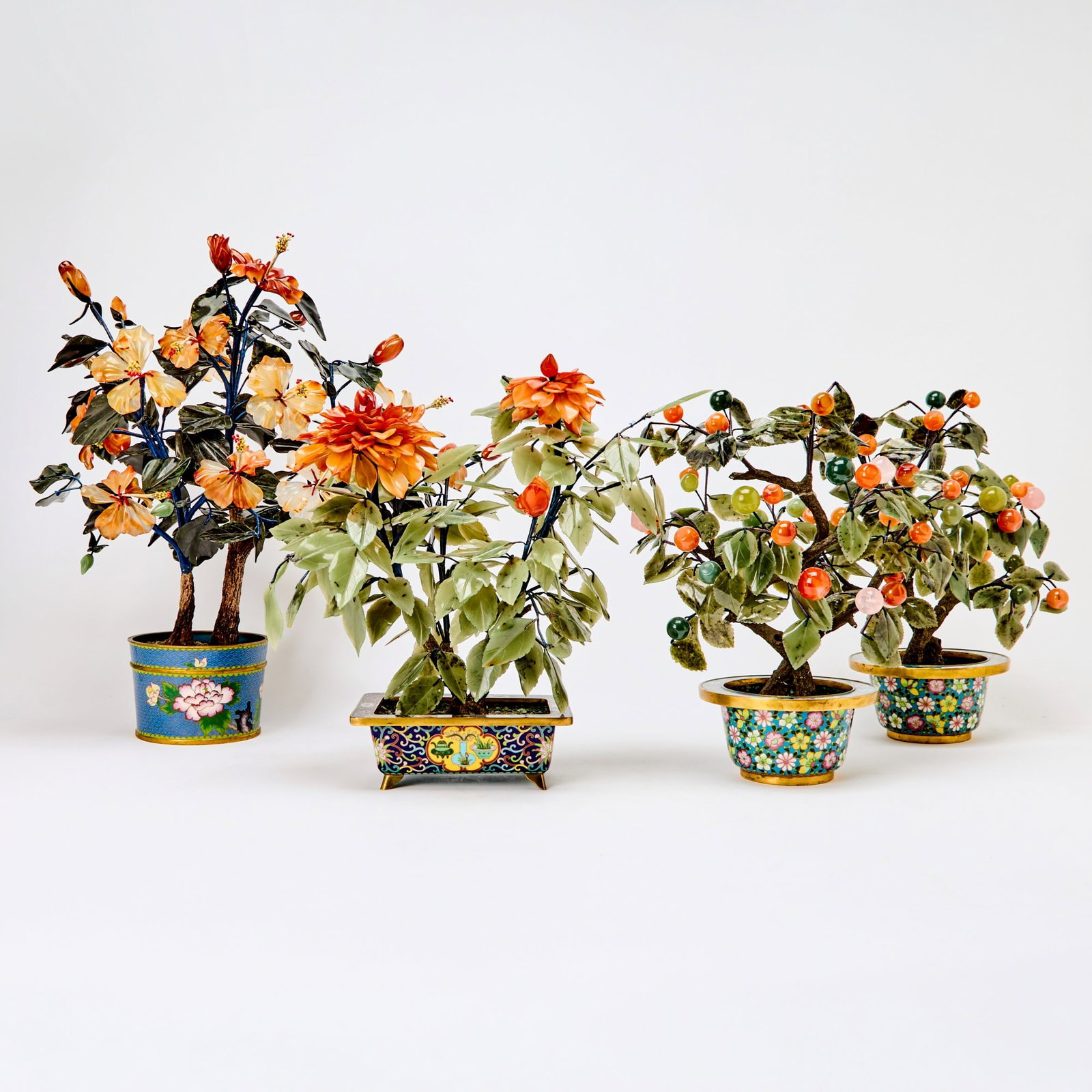 Four Chinese Hardstone and Cloisonne Enamel Potted Plants 20th century: Realistically carved with leaves and blossoms borne on branches issuing from the pots. (Heights of tallest 19 inches)