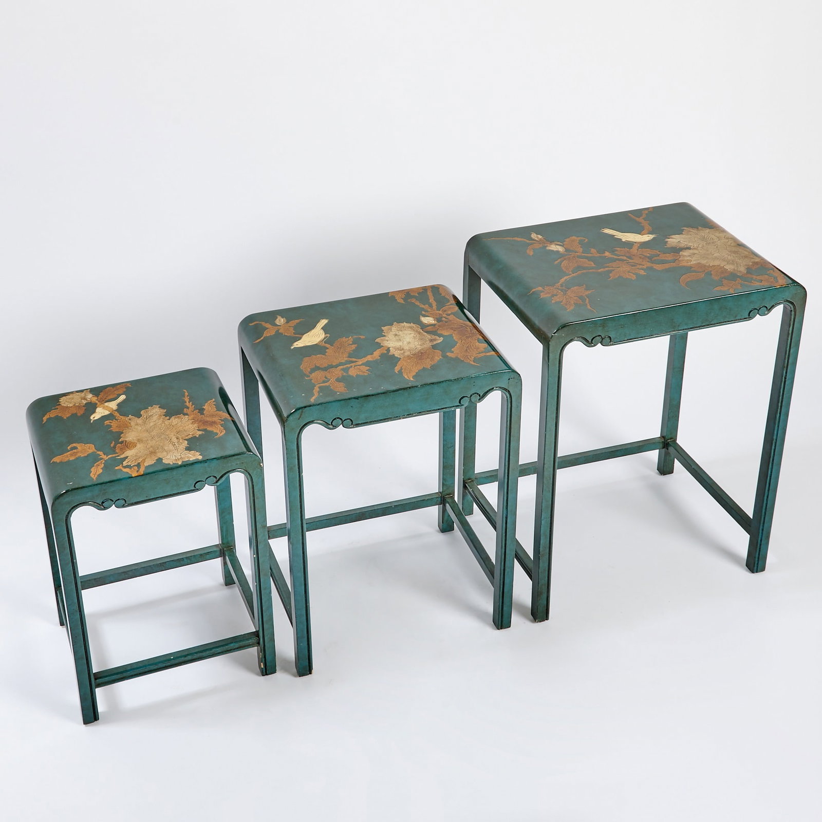 Nest of Three Japanese Lacquer Tables 20th Century: The top surfaces decorated in gilt with flowering branches and birds. (Height of largest 24 inches)