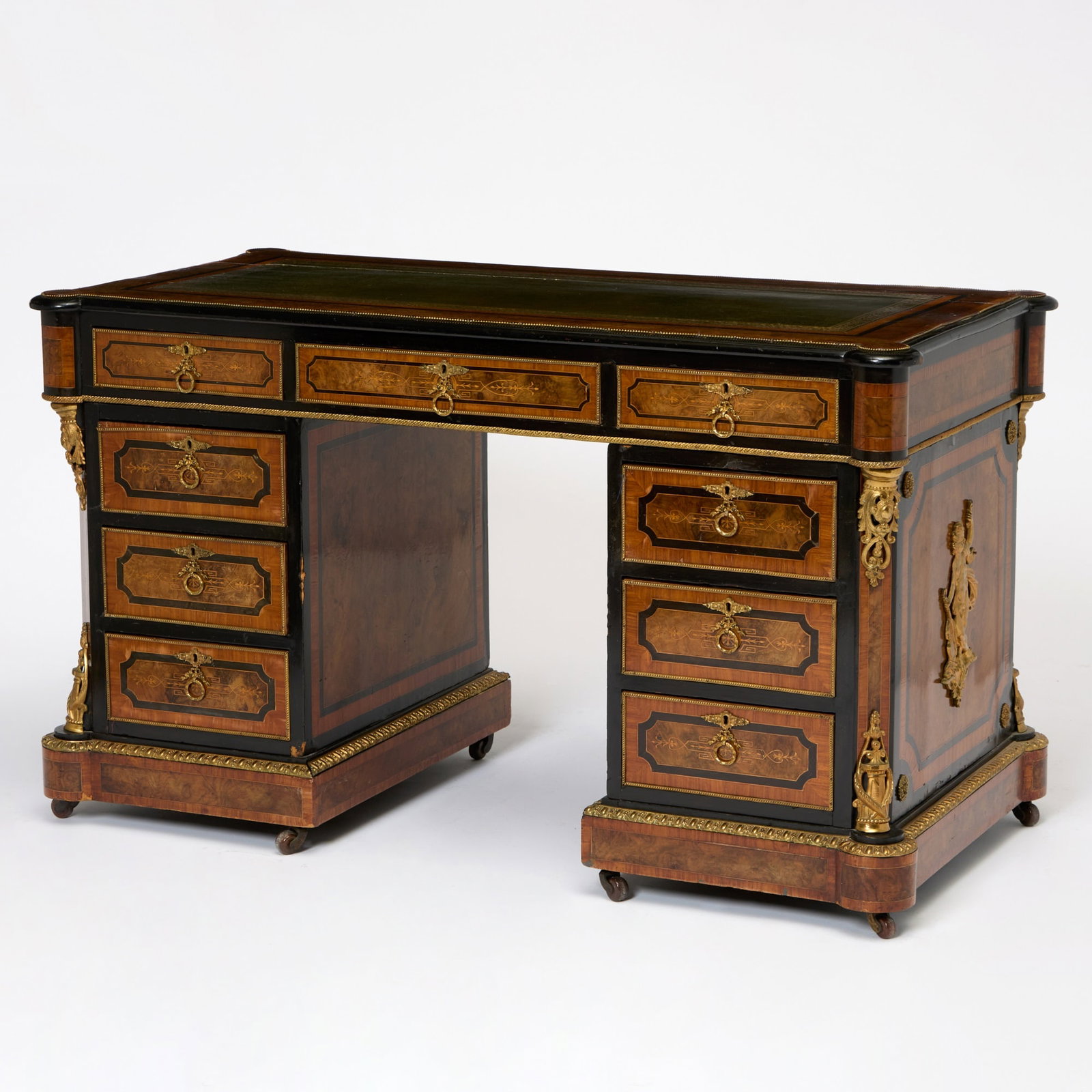 Napoleon III Gilt-Metal Mounted Ebonized and Inlaid Burlwood Pedestal Desk: Third quarter 19th century The top with an inset leather writing surface, above three frieze drawers, each pedestal with three drawers, on a molded base. Height 29 1/2 inches, width 51 inches, depth 2
