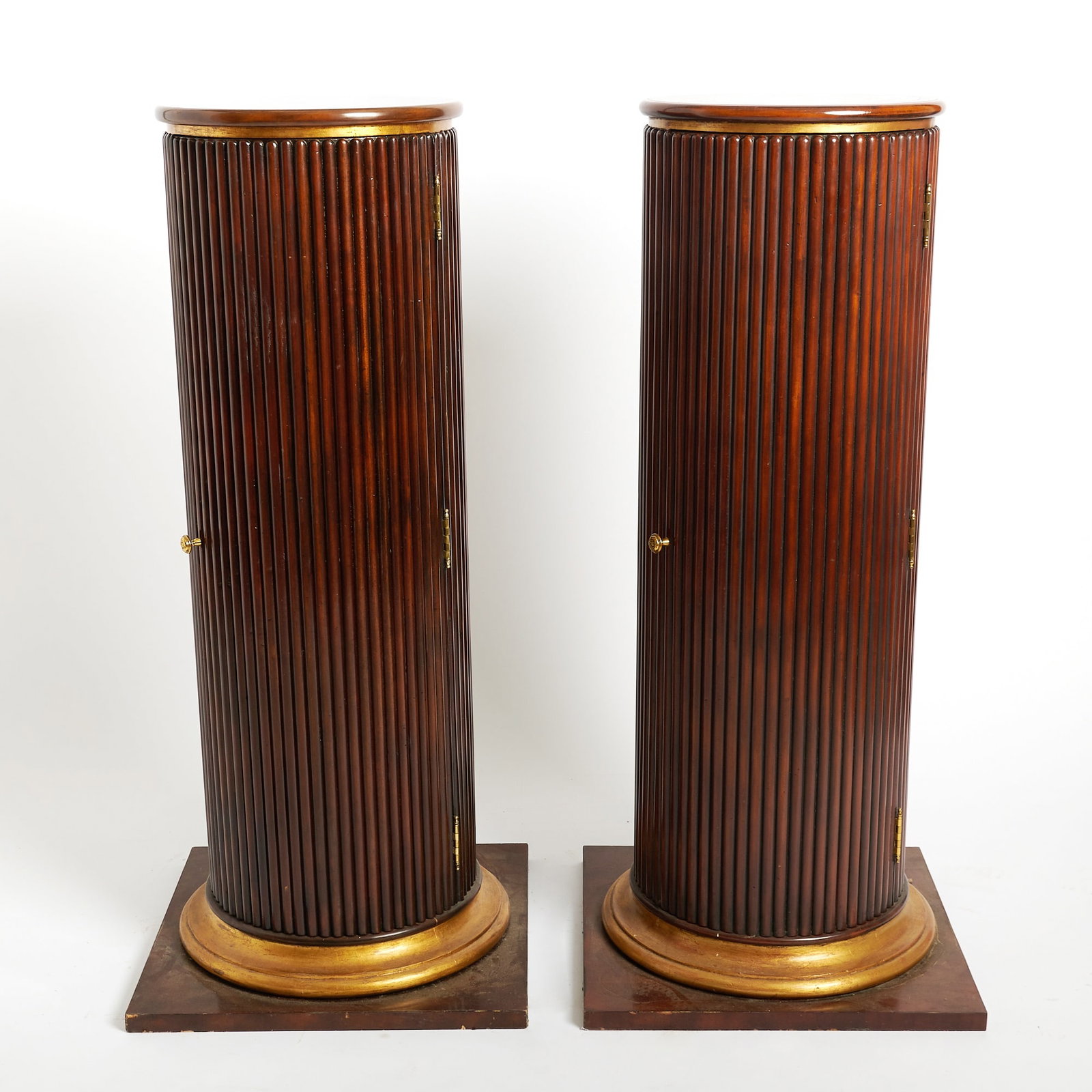 Pair of Continental Reeded Cylindrical Mahogany Pedestal Cupboards: Height 45 1/2 inches, diameter of top 15 1/4 inches.