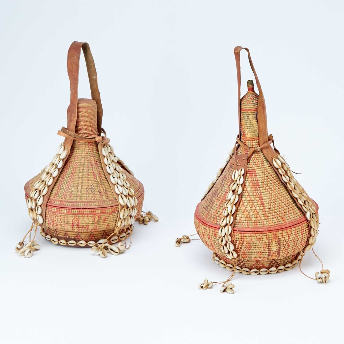 Two Ethiopian Harari Baskets Made of Woven Grass, Leather and Beaded Shells: Early to mid-20th centuryHeight 14 inches.