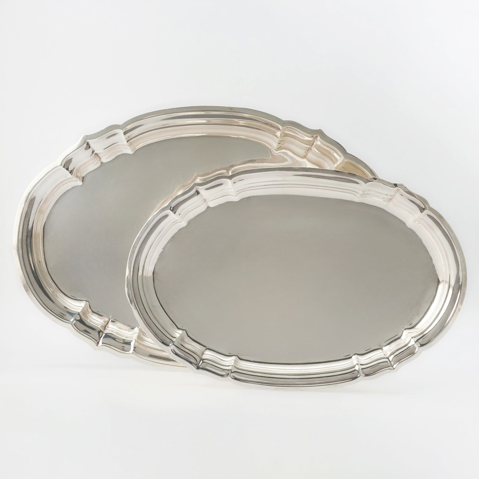 Graduated Pair of Reed & Barton Sterling Silver "Newport" Pattern Platters: Mid 20th century Each shaped oval. Lengths 20 3/4 inches and 17 3/4 inches, total approximately 100 ounces.