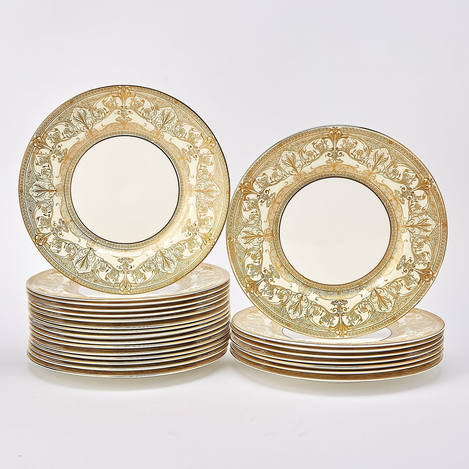 Set of Twenty-Four Royal Worcester Gilt Decorated Porcelain Dinner Plates: In the Harewood pattern Each with a white center continuing to an ornate foliate decorated border, gilt company stamp mark and pattern name on the back. Diameter 10 inches (24) one plate has a