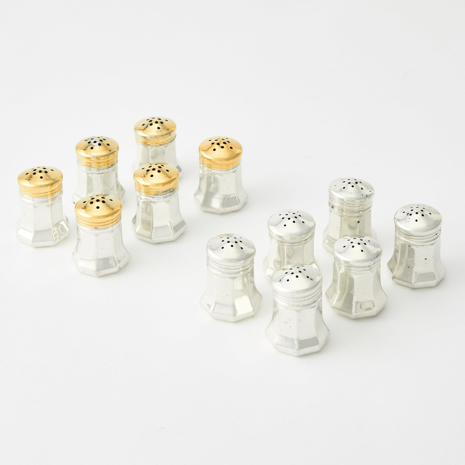 Set of Twelve Cartier Sterling Silver Individual Salt and Pepper Shakers: Mid 20th century Including six with gilt tops. Heights 1 1/4 inches, total approximately 2 ounces. (12) Generally good condition overall