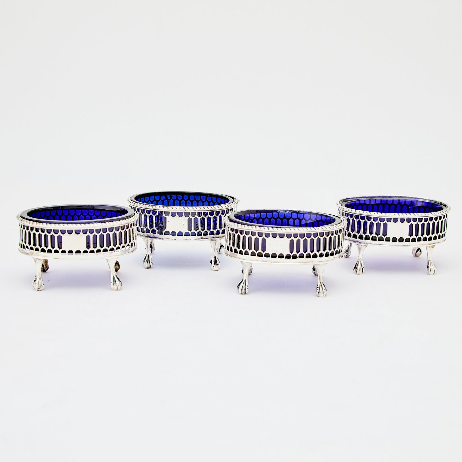Set of Four George III Scottish Silver Open Salts: Patrick Robertson, Edinburgh, 1773 Each oval with pierced body, raised on claw and ball feet. Height 1 3/4 inches (4.5 cm), length 3 1/8 inches (8 cm), total approximately 6 ounces, weighable.
