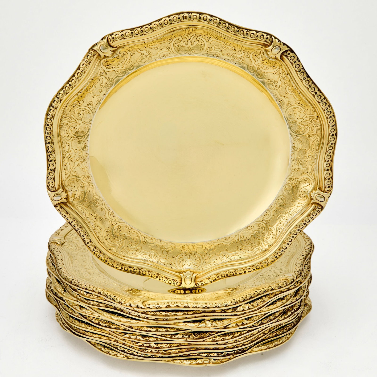 Set of Twelve French Silver Gilt Lunch Plates: Maison Aucoc, Paris, late 19th/early 20th century Each shaped circular, with foliate scroll border. Diameter 9 3/4 inches (25 cm), total approximately 200 ounces.