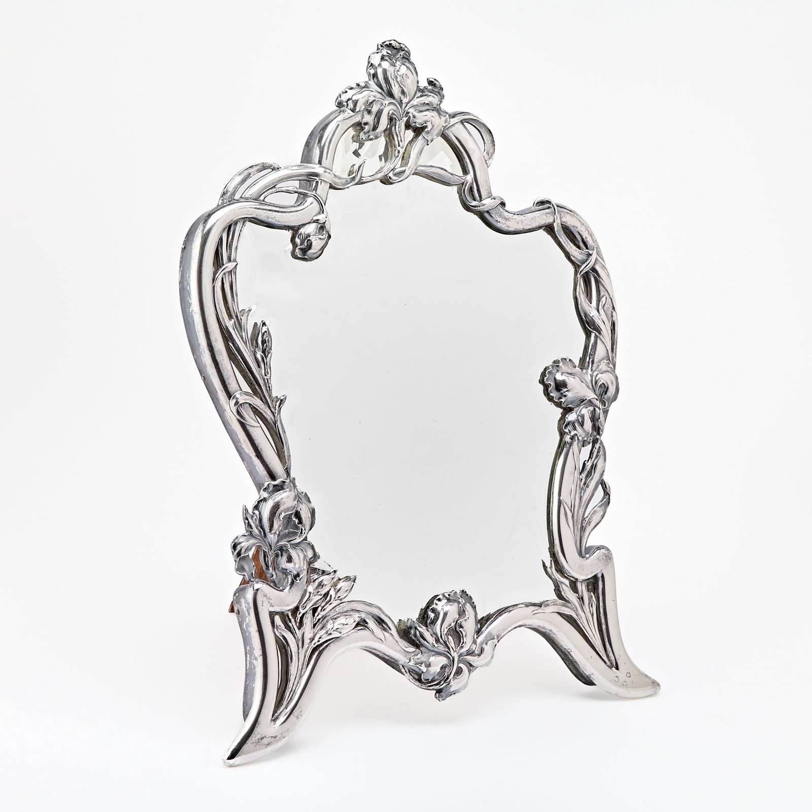 Austrian Art Nouveau Silver Table Mirror: Franz Rumwolf, Vienna, early 20th century The shaped cartouche frame with border of climbing irises with sweeping stems and leaves framing beveled glass. Height 24 1/2 inches (62 cm), width 17 3/4 inc