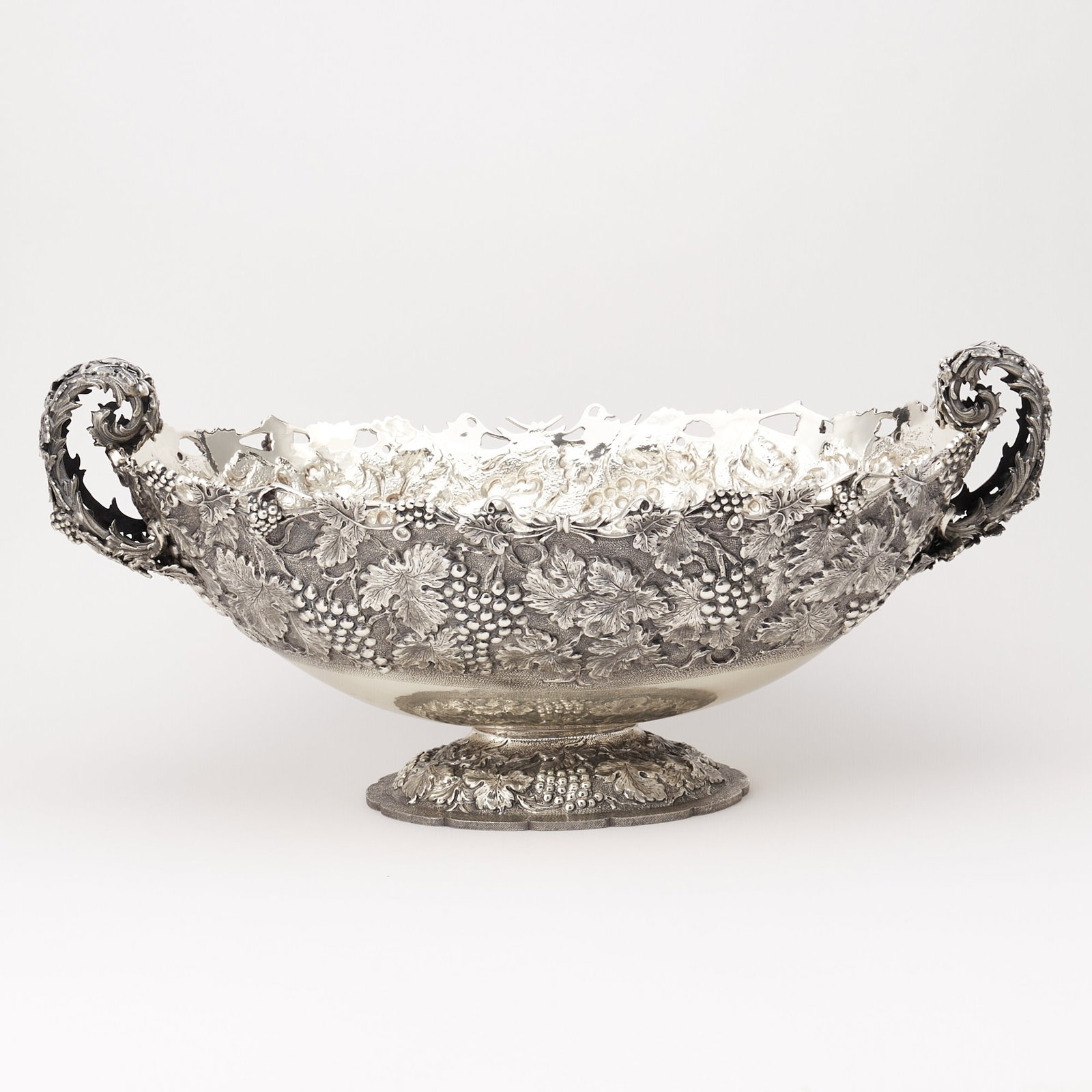 Italian Silver Large Centerpiece Bowl: Late 20th century Oval, the body chased with grape clusters and vines, with upswept foliate scroll handles. Height over handles 11 inches (28 cm), length over handles 24 1/2 inches (62.3 cm), approxim