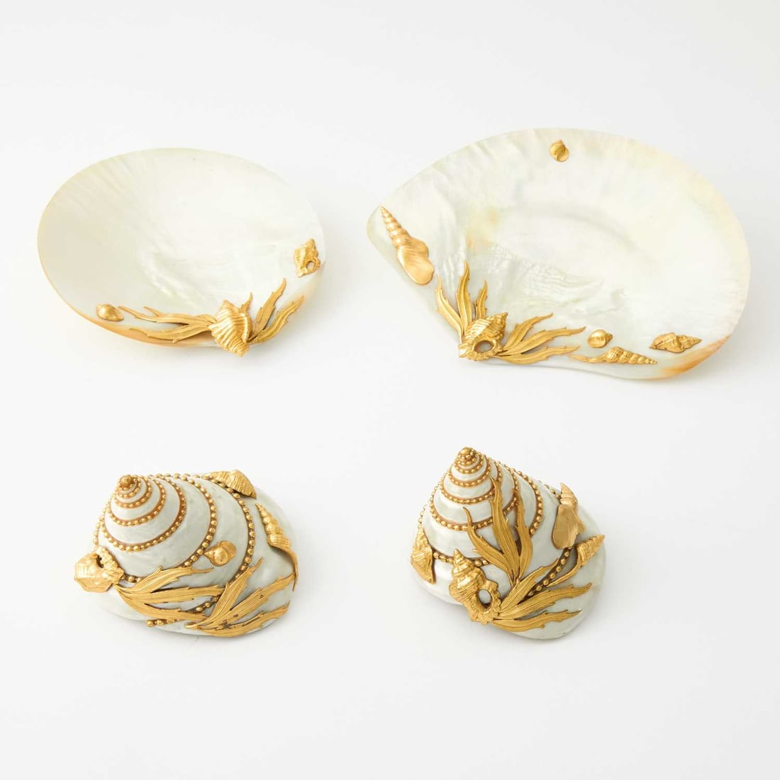 Two Pairs of Fine French Gilt-Bronze Mounted Mother-of-Pearl Shells: In the manner of Juste-Aurele Meissonier, circa 1900 The nautilus shells applied with gilt-bronze mounts, the other pair rises to a spiral finial encircled by applied gilt-bronze bands. Width 9 1/4 in