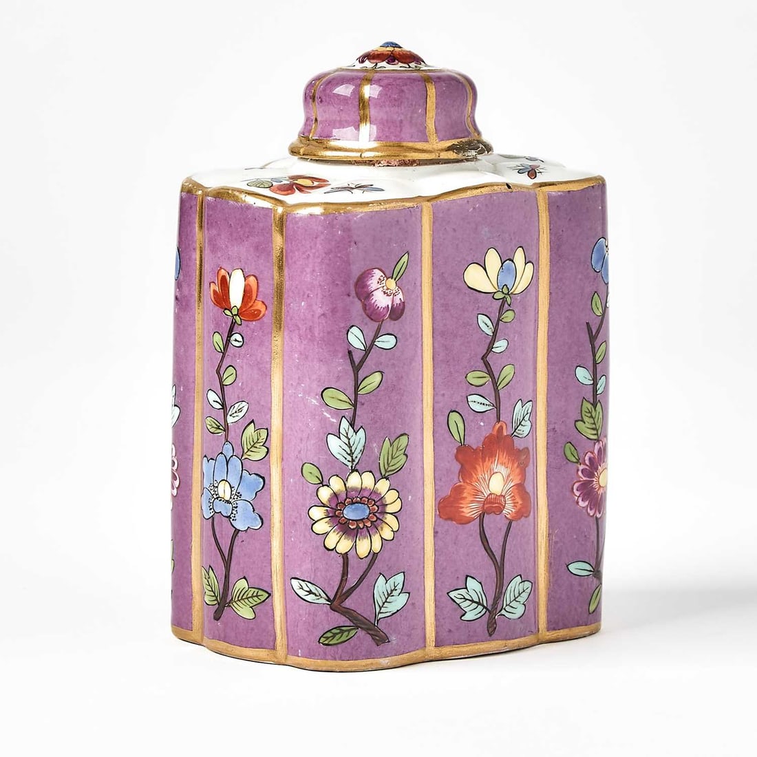 Meissen Purple-Ground Porcelain Tea Cannister and Cover: Circa 1735 The lobed-rectangular fluted body with panels painted with branches of individual blossoms on a purple ground, with an octagonal lobed cover; with blue crossed swords mark. Height 4 3/4 inc