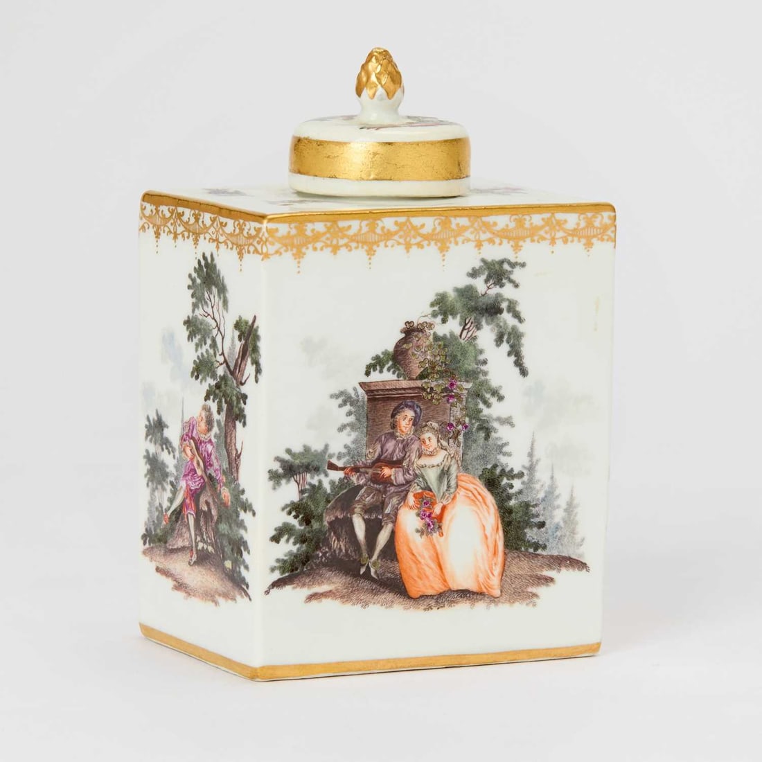 Meissen Porcelain Tea Canister and Cover: Circa 1740 Each side finely painted in colors with scenes of figures in gardens after Watteau, below a band of elaborate gilt laub-und-bandelwerk and circular cover with pinecone finial. Height 4 7/8 