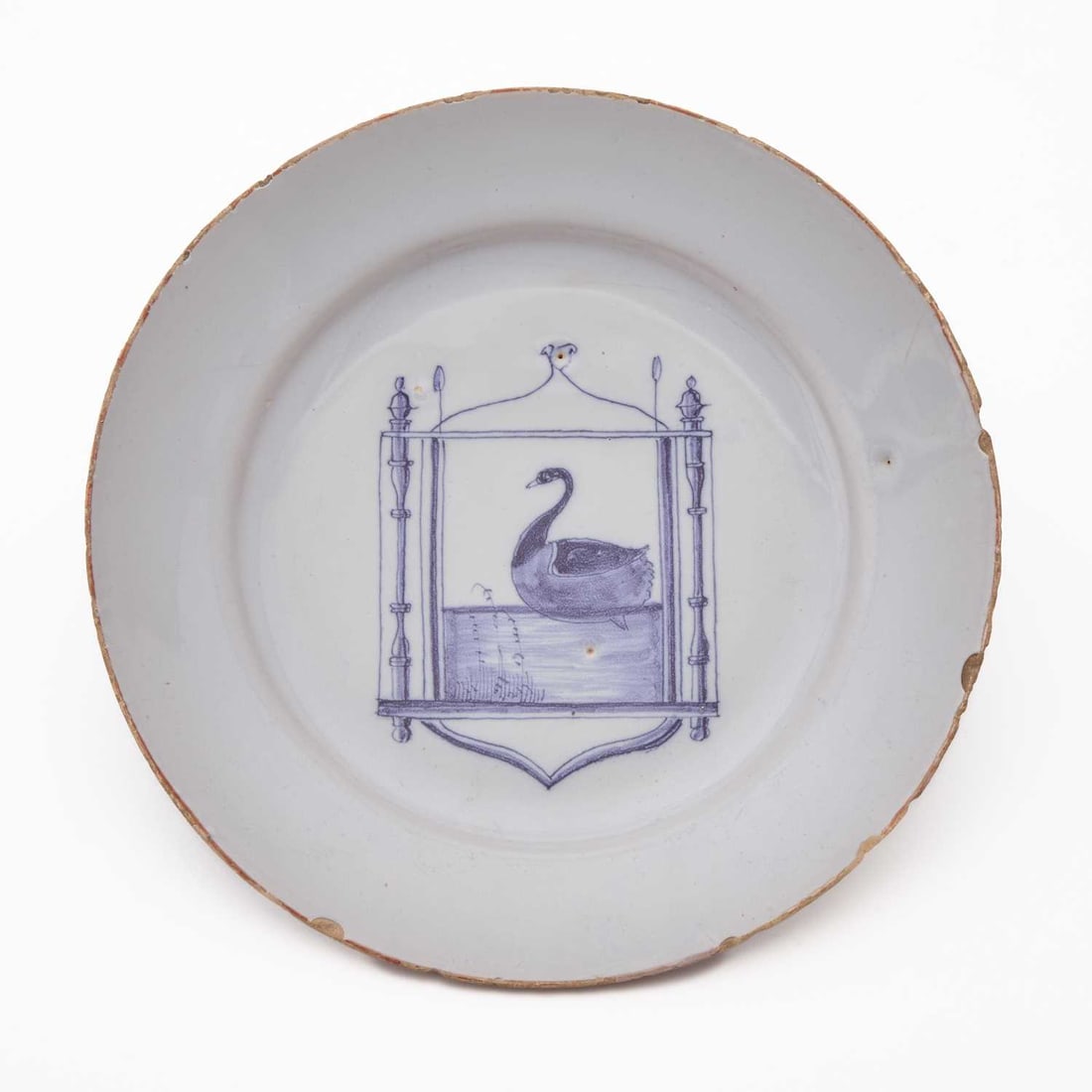 English Delft Blue and White Plate: Circa 1750, probably Bristol Depicting a swan swimming within an ogival frame with turned columnar supports. Diameter 8 5/8 inches (21.9 cm). Provenance: Alistair Sampson, London. Some c