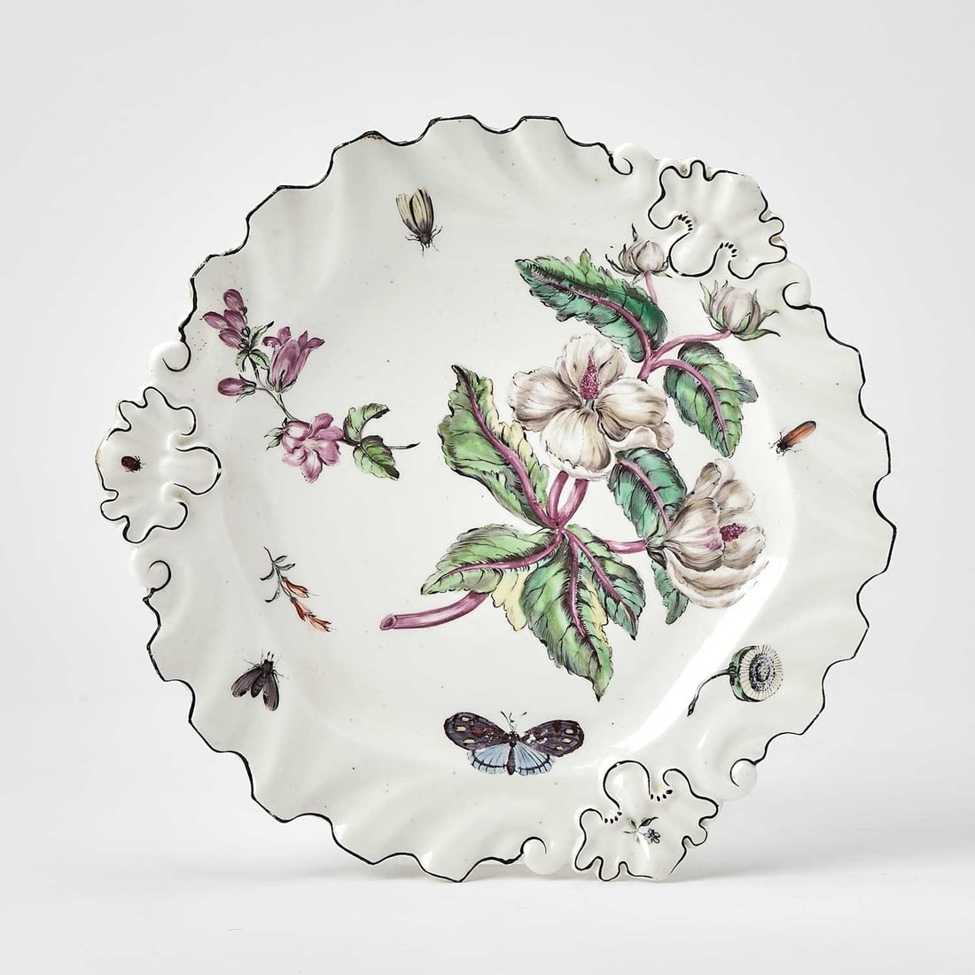 Chelsea 'Hans Sloane' Plate: Circa 1755 Of silver shape with a brown rim, the center painted with leafy blossoms, insects, and small leaf and flower sprigs. Diameter 10 1/2 inches (26.7 cm). For another example, see Sotheby's, Lo