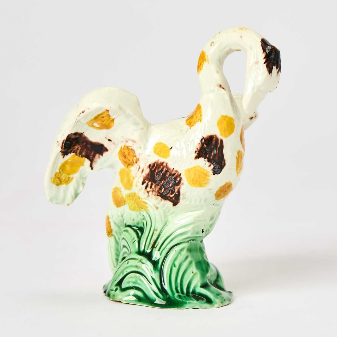 Staffordshire Pearlware Model of a Swan: Circa 1800 Modeled about to take flight, with manganese and ochre markings on a green base. Height 4 1/2 inches (11.5 cm).