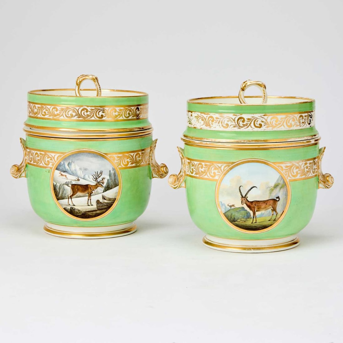 Pair of Derby Apple-Green Ground Ice Pails, Covers and Liners: Circa 1800 Each bucket-shaped bowl finely painted with exotic animals in landscapes within circular gilt-lined cartouches superimposed on a band of trailing foliage flanked by shell handles, all below