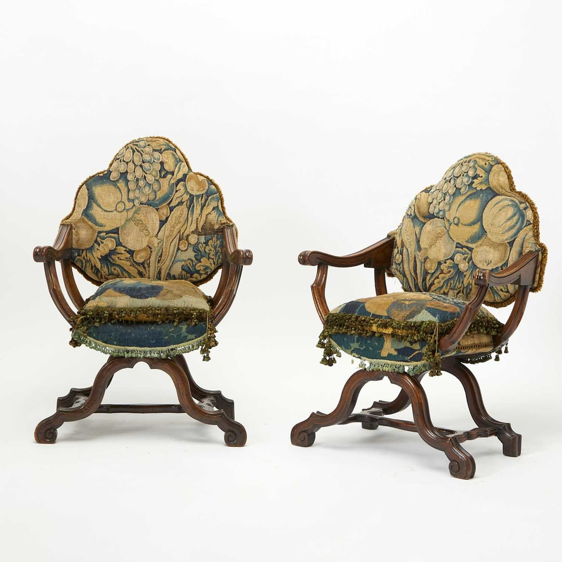 Pair of Louis XIV Carved Walnut Armchairs: Late 17th century Each with serpentine back and bowed seat upholstered with 17th century Verdure tapestry, on cabriole-form supports with downswept