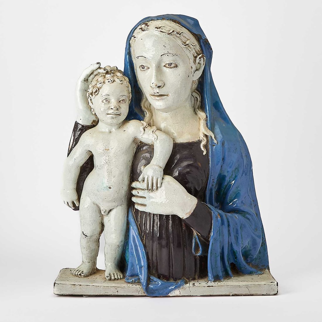 Italian Glazed Majolica Plaque: In the manner of Luca Della Robbia (1400-1482), mid-20th century, Molded in high relief, depicting the Virgin and Child in blue and white glaze. Height 23 inches (58.4 cm), width 18 1/2 inches (46.9 c