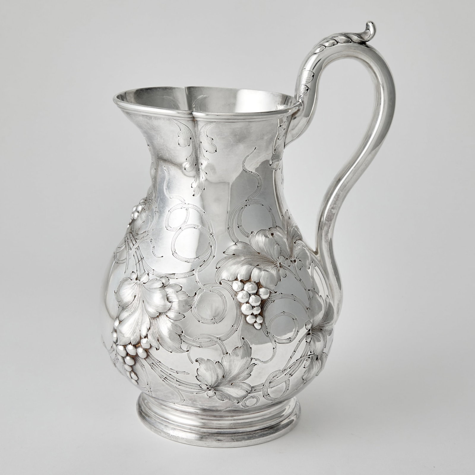 American Silver Water Pitcher: Lincoln & Foss, Boston, 1850s Baluster-form, chased with grape clusters and vines, with leaf-capped scroll handle. Height 12 inches, approximately 37 ounces.