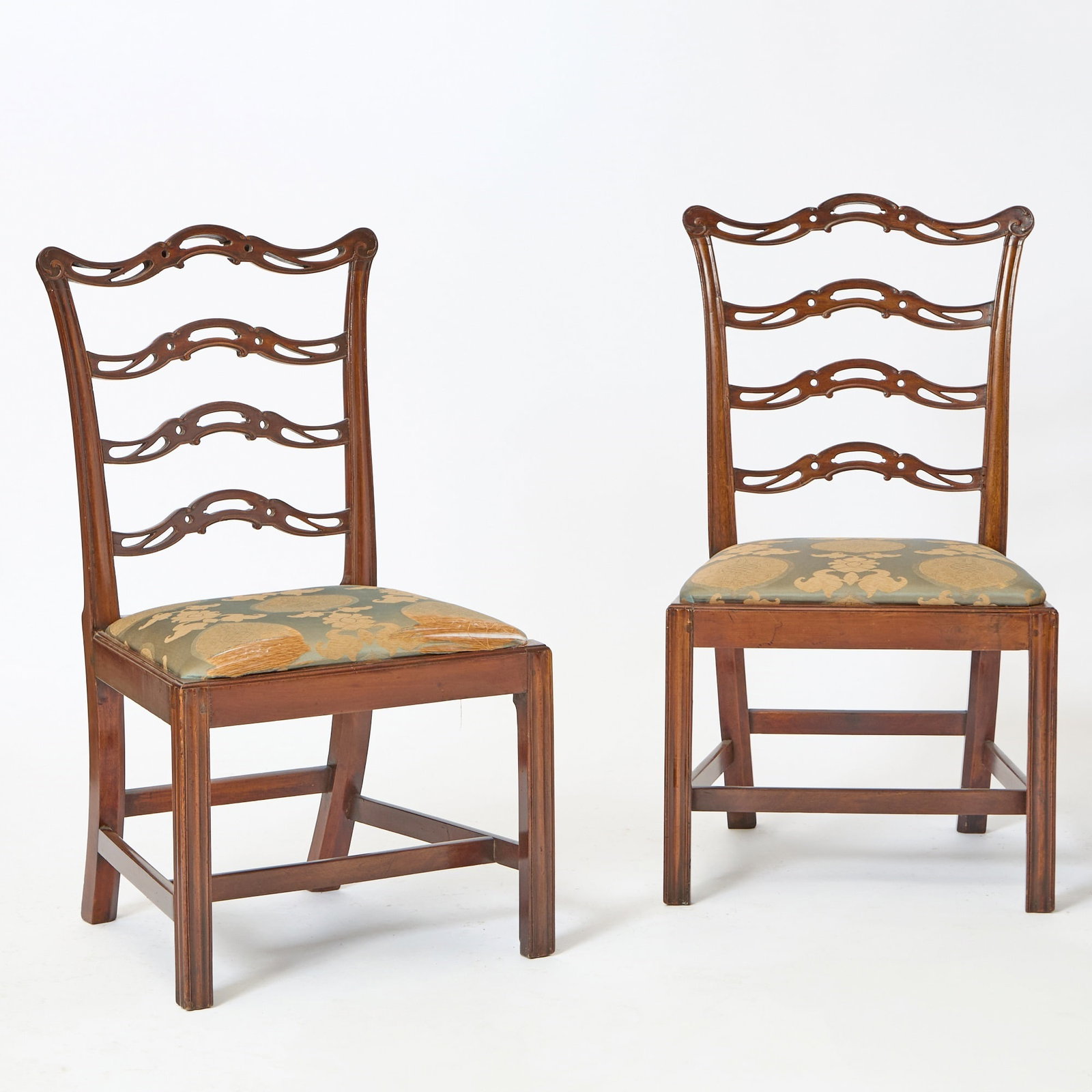 Pair of Chippendale Carved Mahogany Side Chairs: Massachusetts, late 18th century Each crest with scroll-carved terminals above three shaped and pierced slats, on a trapezoidal slip seat, raised on molded Marlboro legs, the inside of each front rail